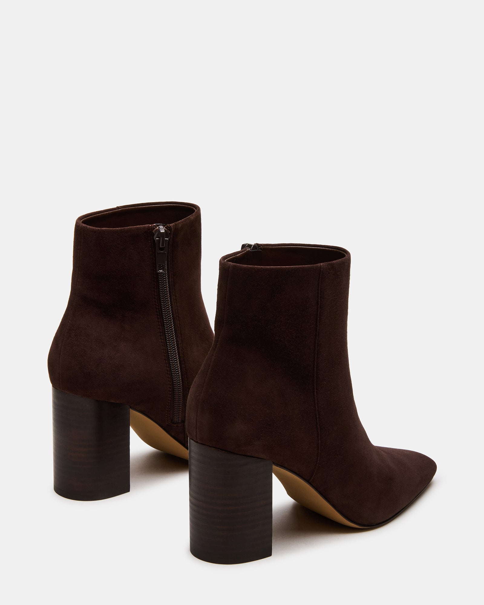 Pair of Aidan ankle boots on a rug, highlighting the suede texture and heel height