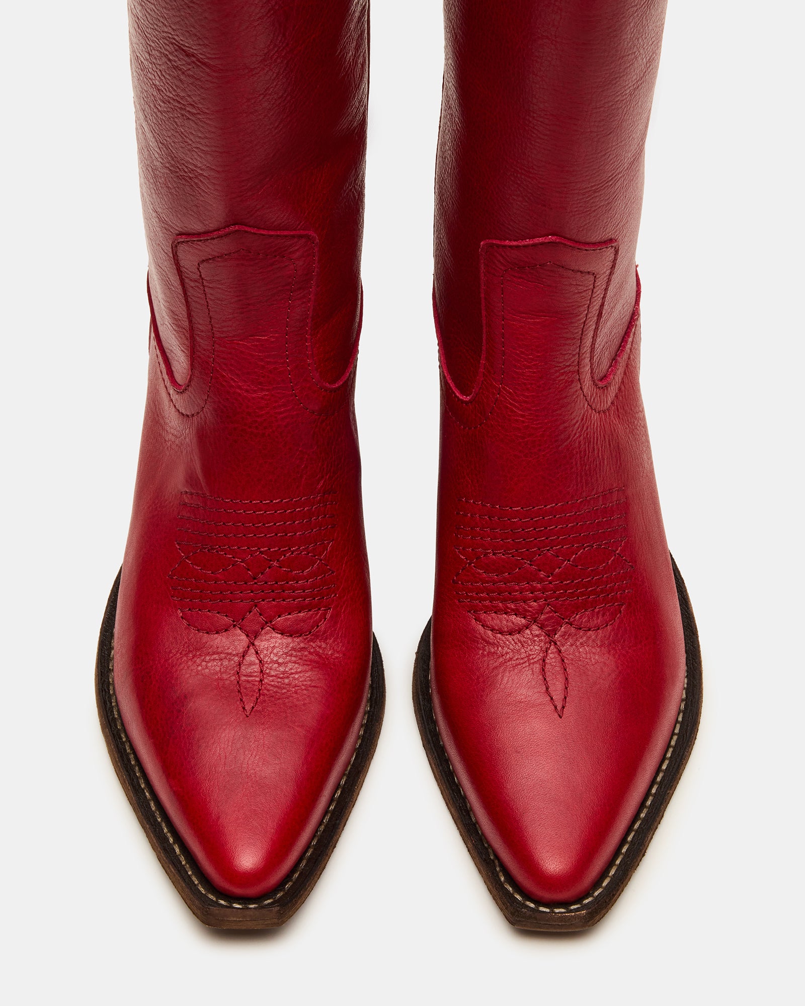Close-up of black pointed toe boots detailing stitching and premium leather texture.