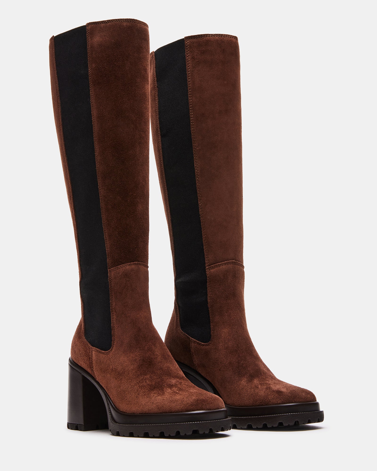 Model wearing brown suede knee high boots with stretch panels in urban setting