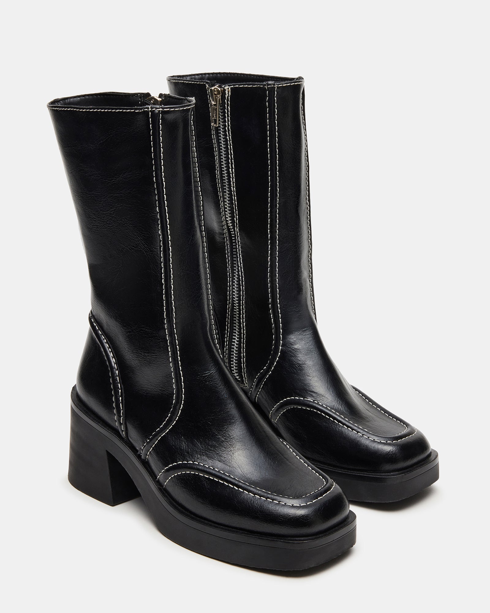 Side angle showing heeled block boots worn with skinny jeans