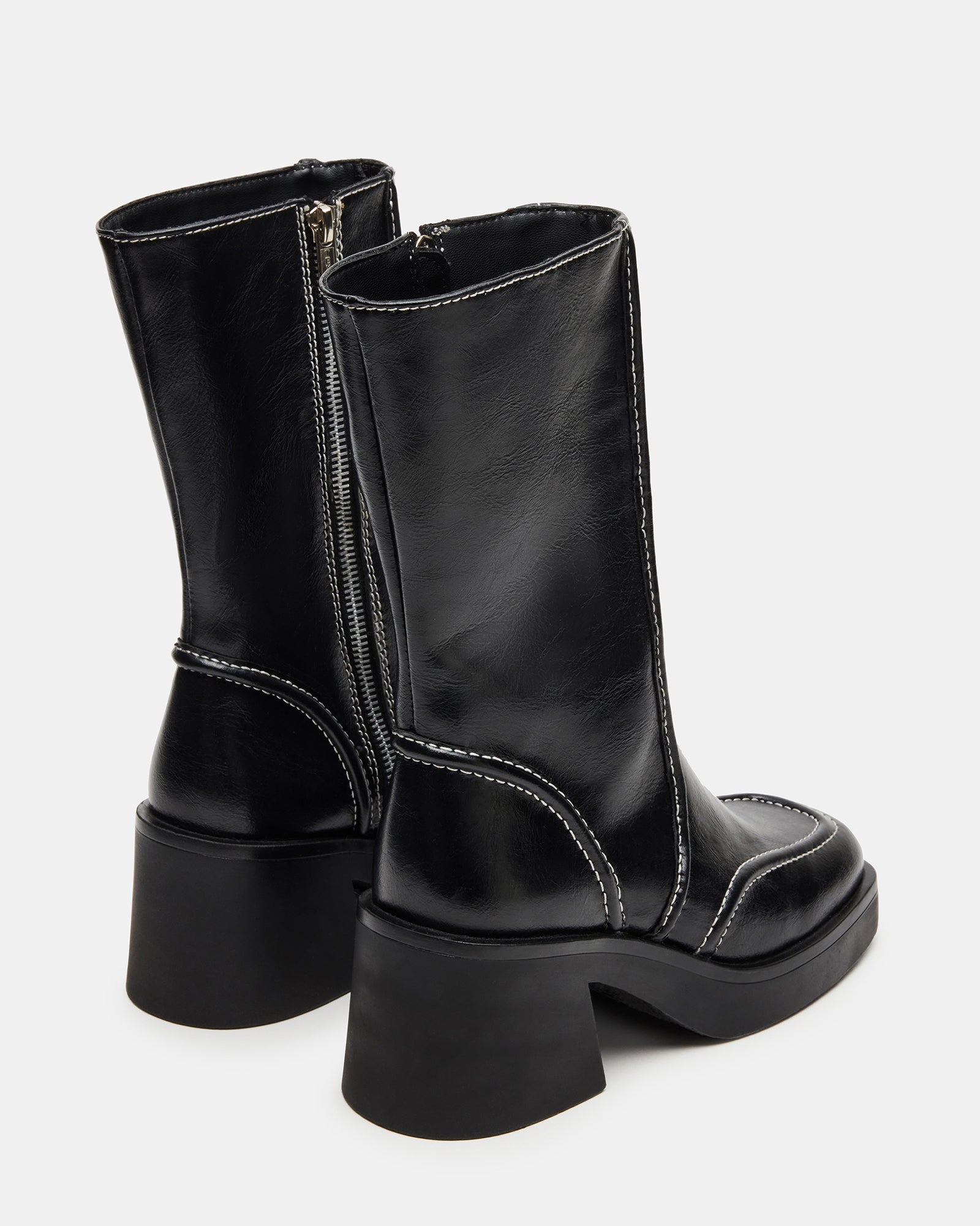 Side angle showing heeled block boots worn with skinny jeans