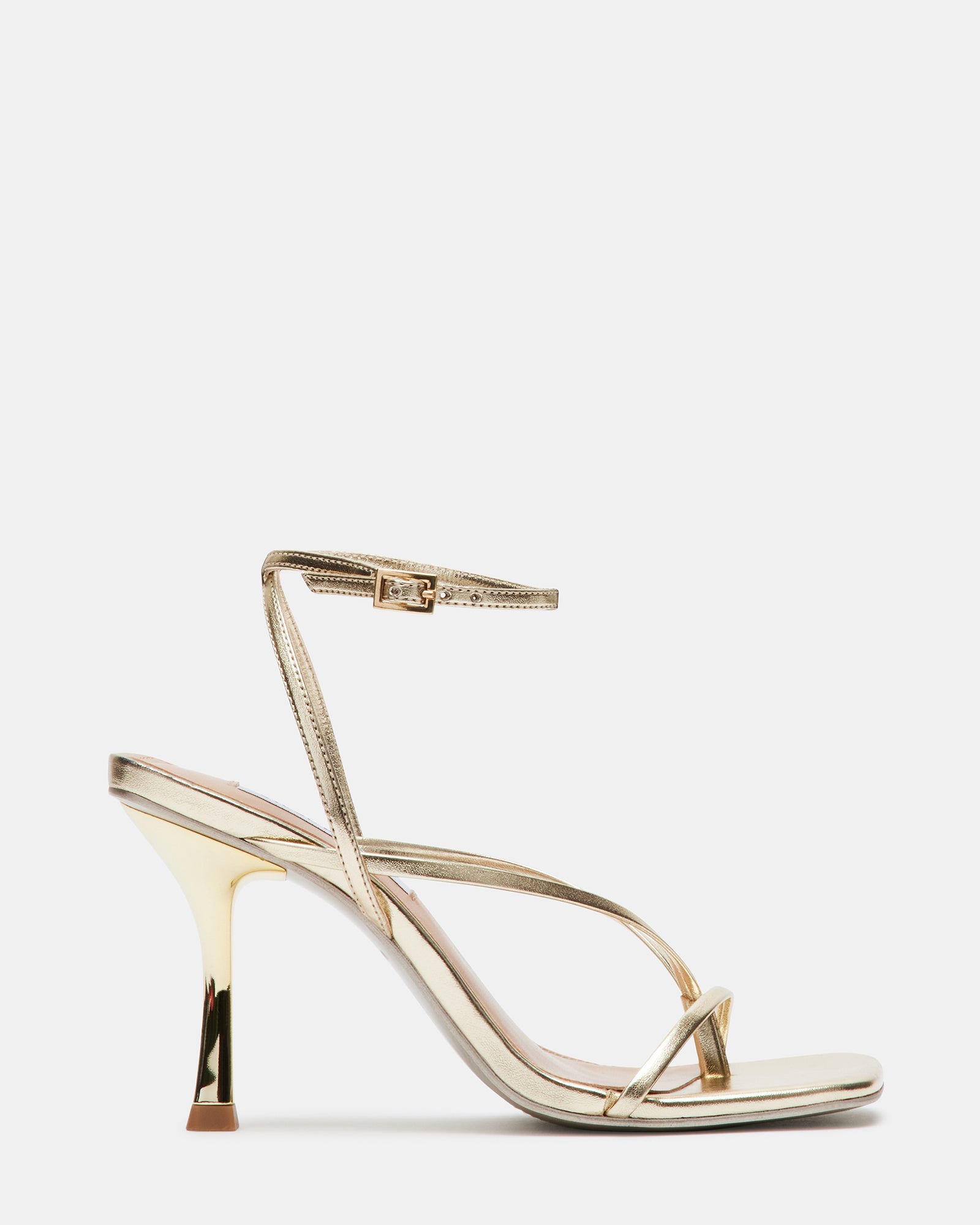 Side angle of ANNIE CHAMPAGNE strappy stiletto heels worn with officewear.