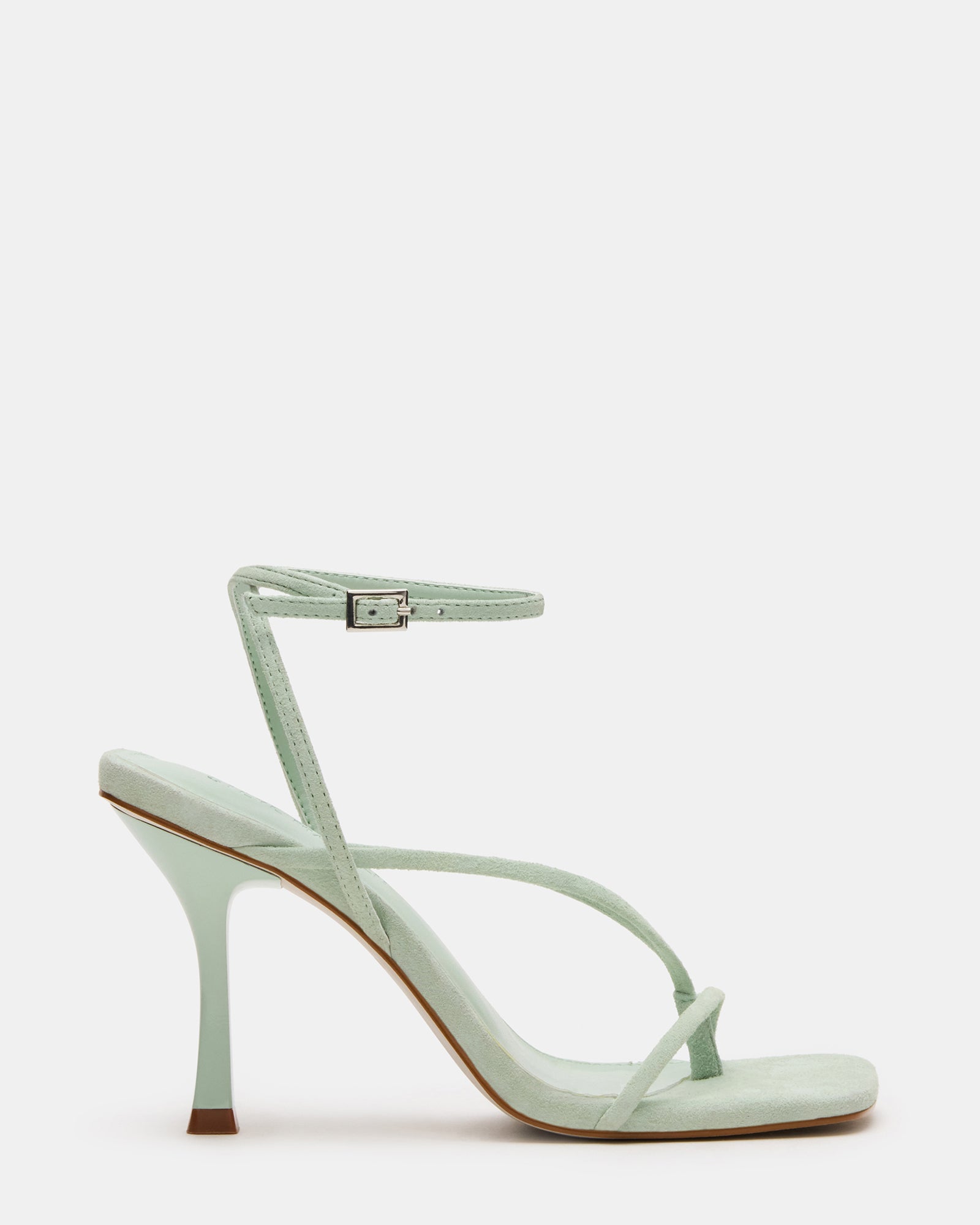 Elegant black stiletto heels with suede finish and strappy design on a fashion runway