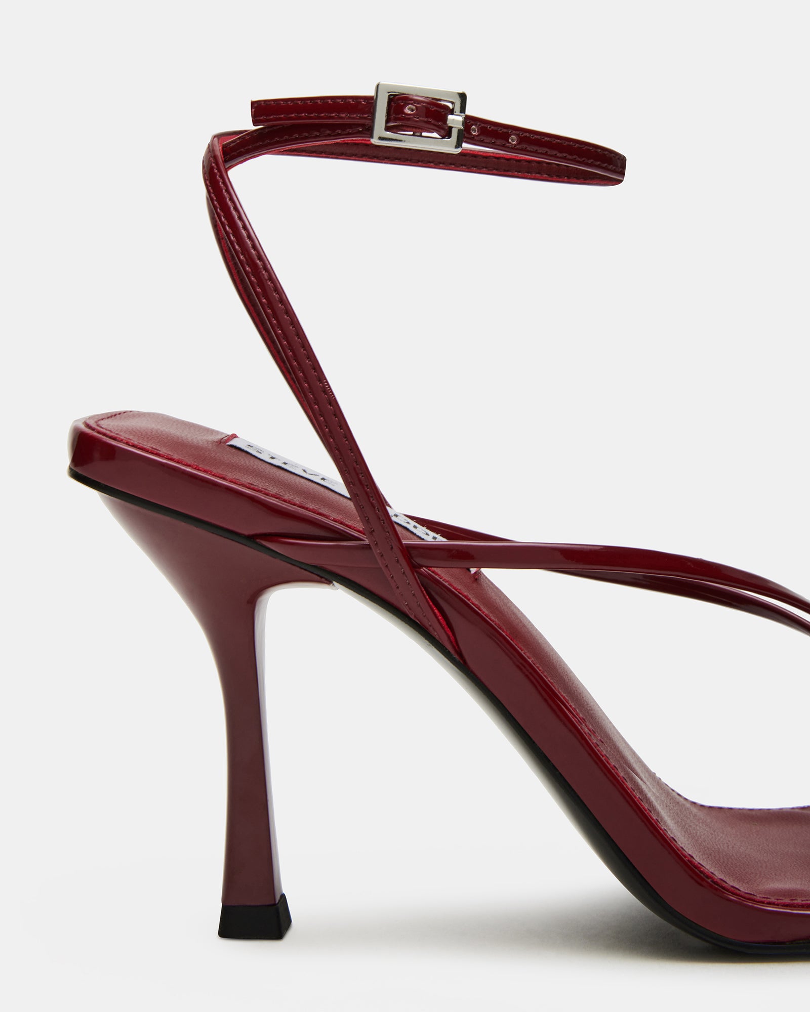 Close-up of wine patent stiletto heel showing texture and finish