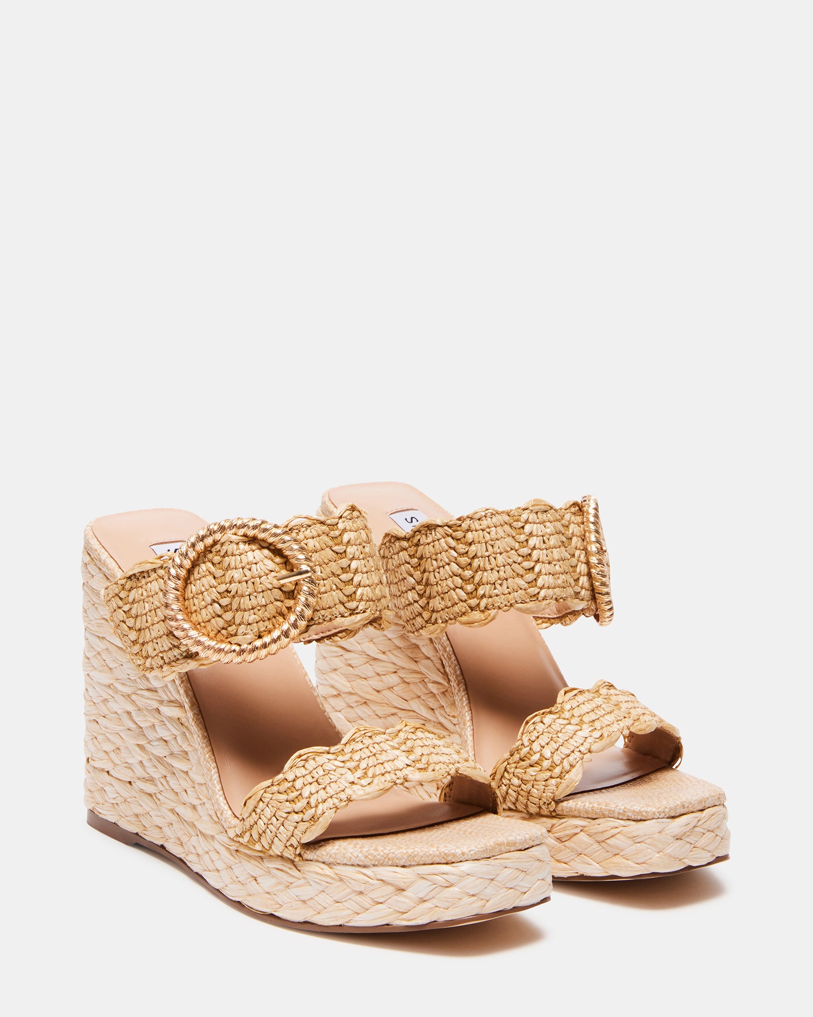 Model wearing raffia wedge sandals outdoors on sunny day
