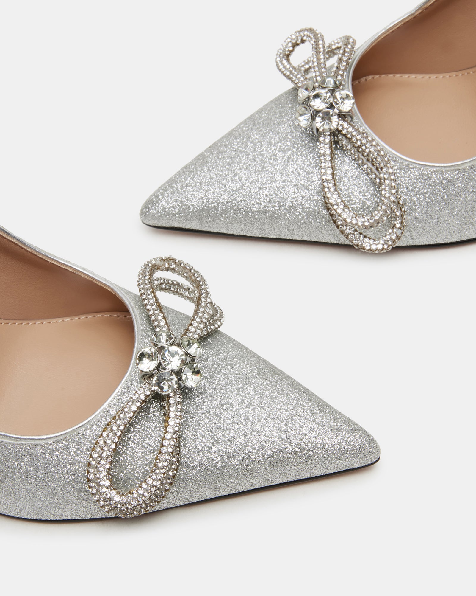 Pointed toe silver heels displayed on marble surface