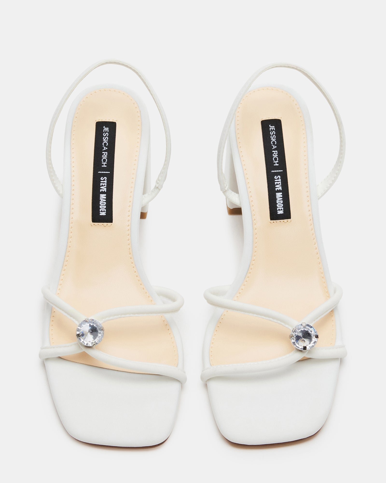 Close-up of white slingback sandals with square toe and embellished strap