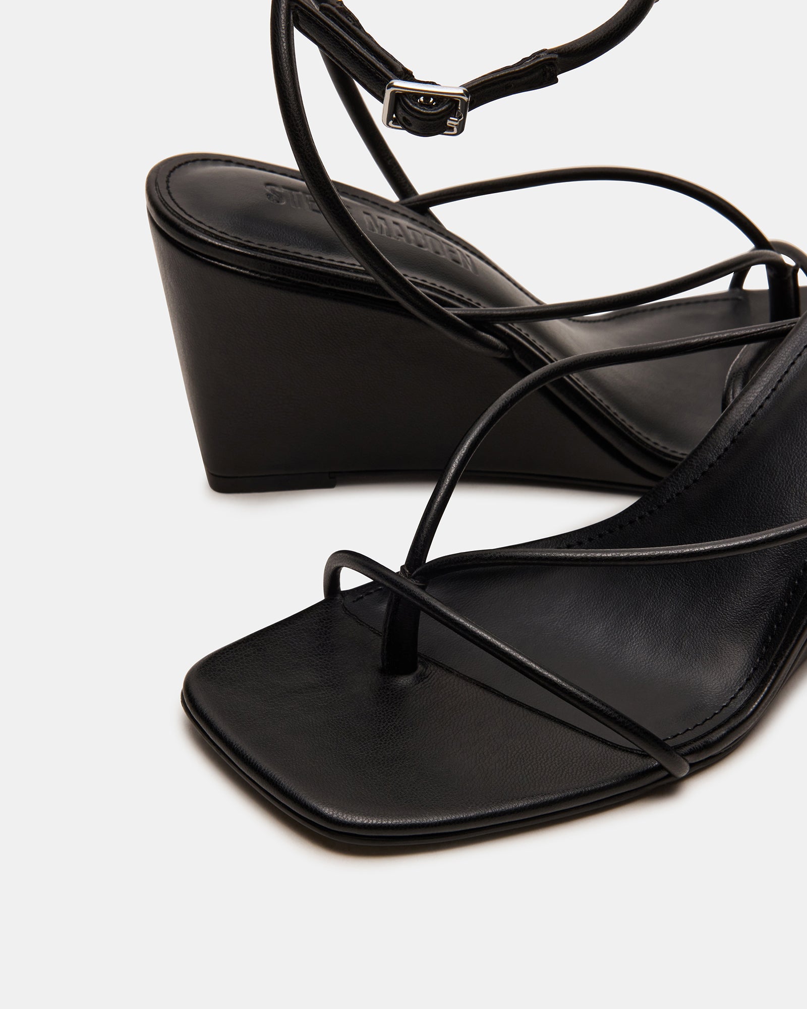 Close-up of the vegan leather upper and synthetic sole of APPA Black wedge sandals
