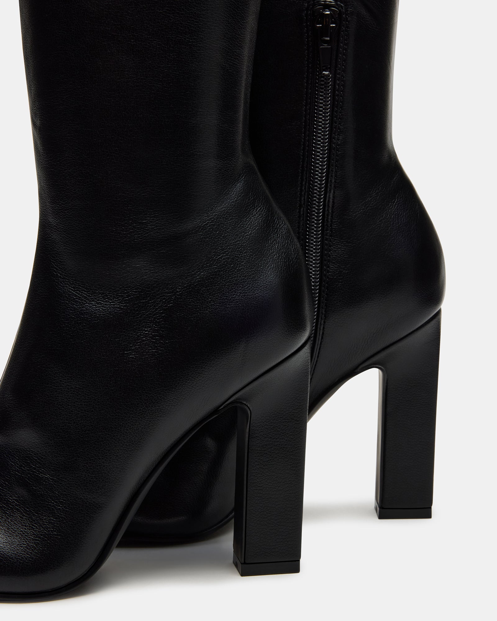 Wide calf knee high boots paired with a midi dress for evening wear