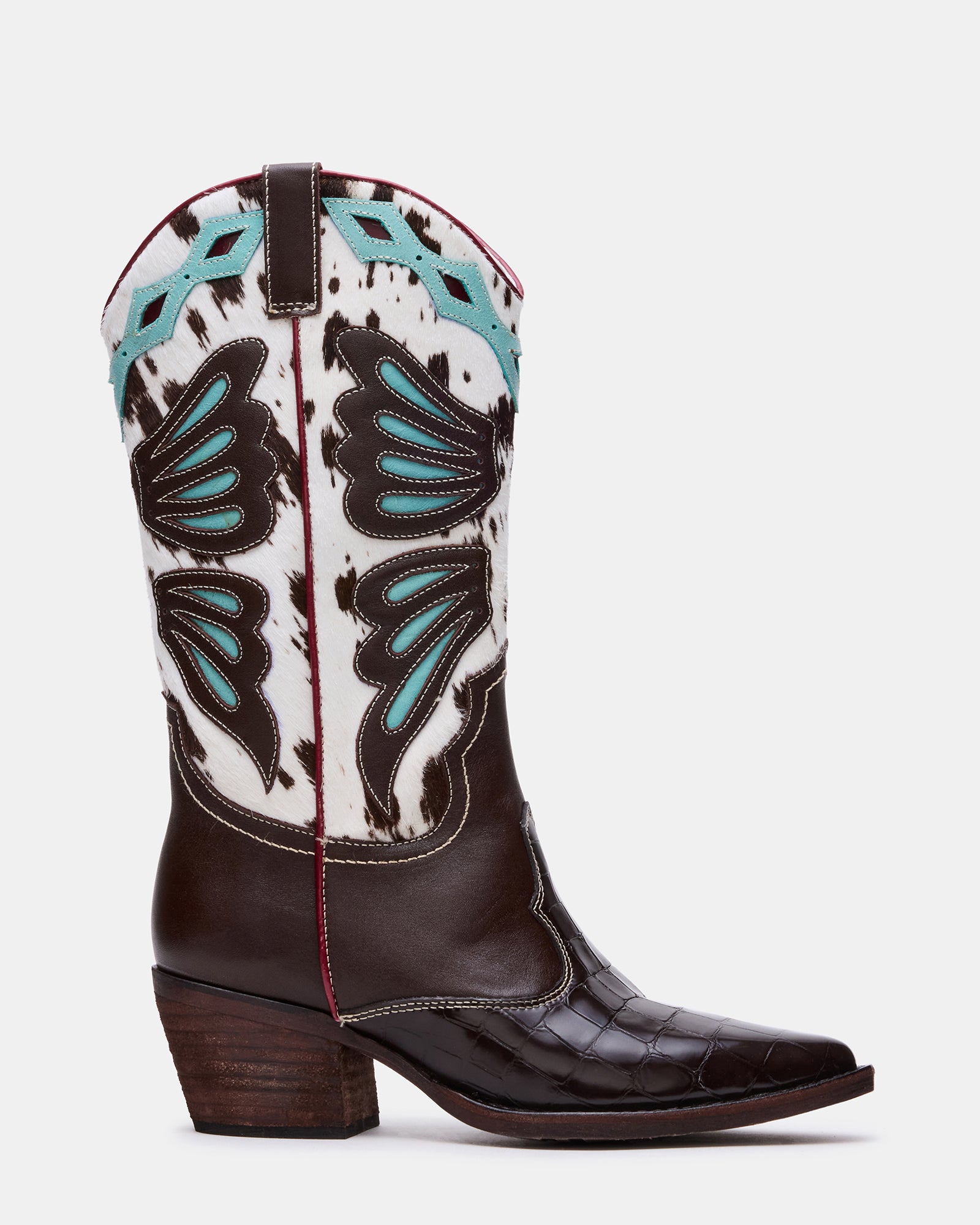 Side angle of women's cowboy boots with pointed toe on rustic wooden floor