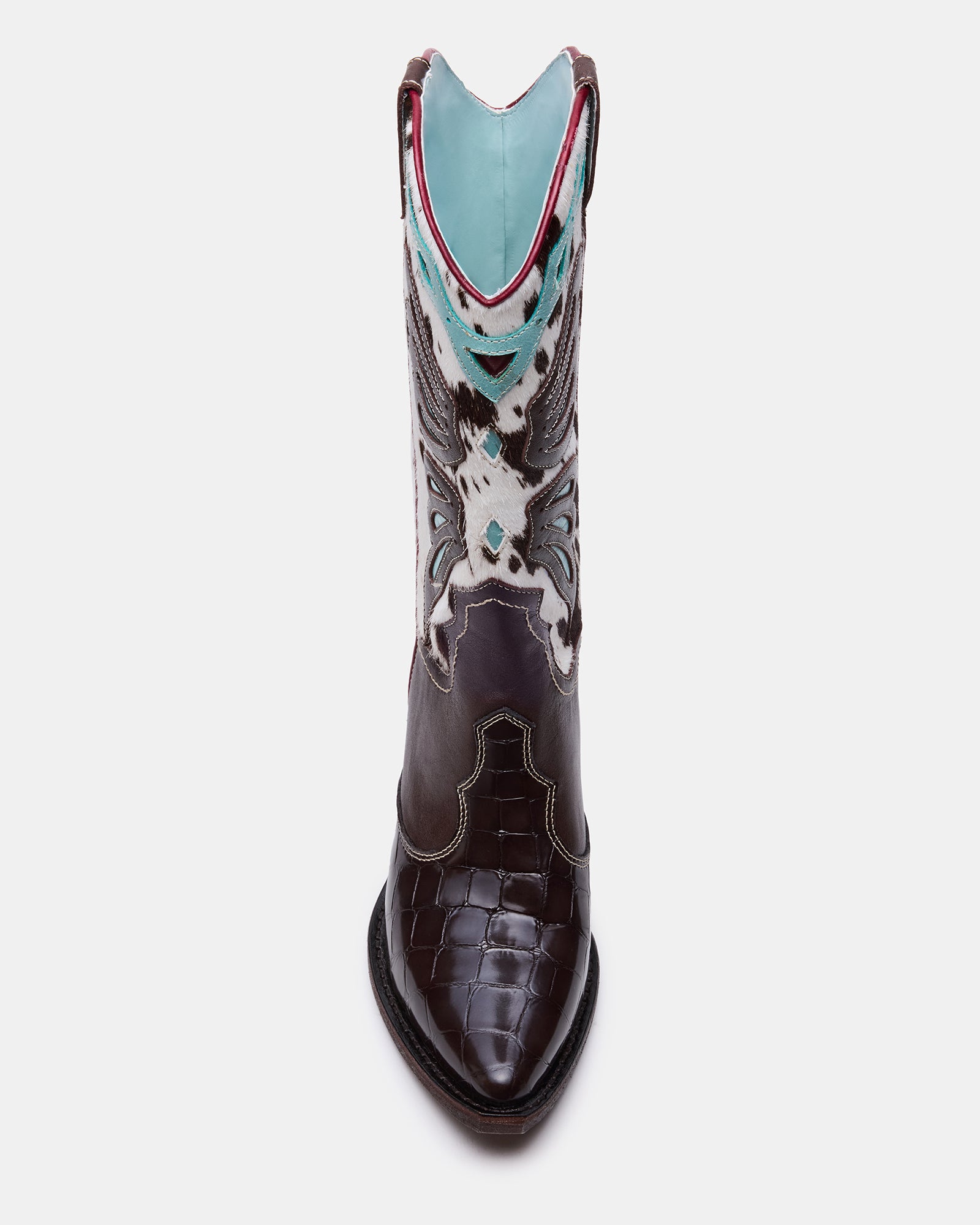 Side angle of womens cowboy boots with pointed toe on rustic wooden floor