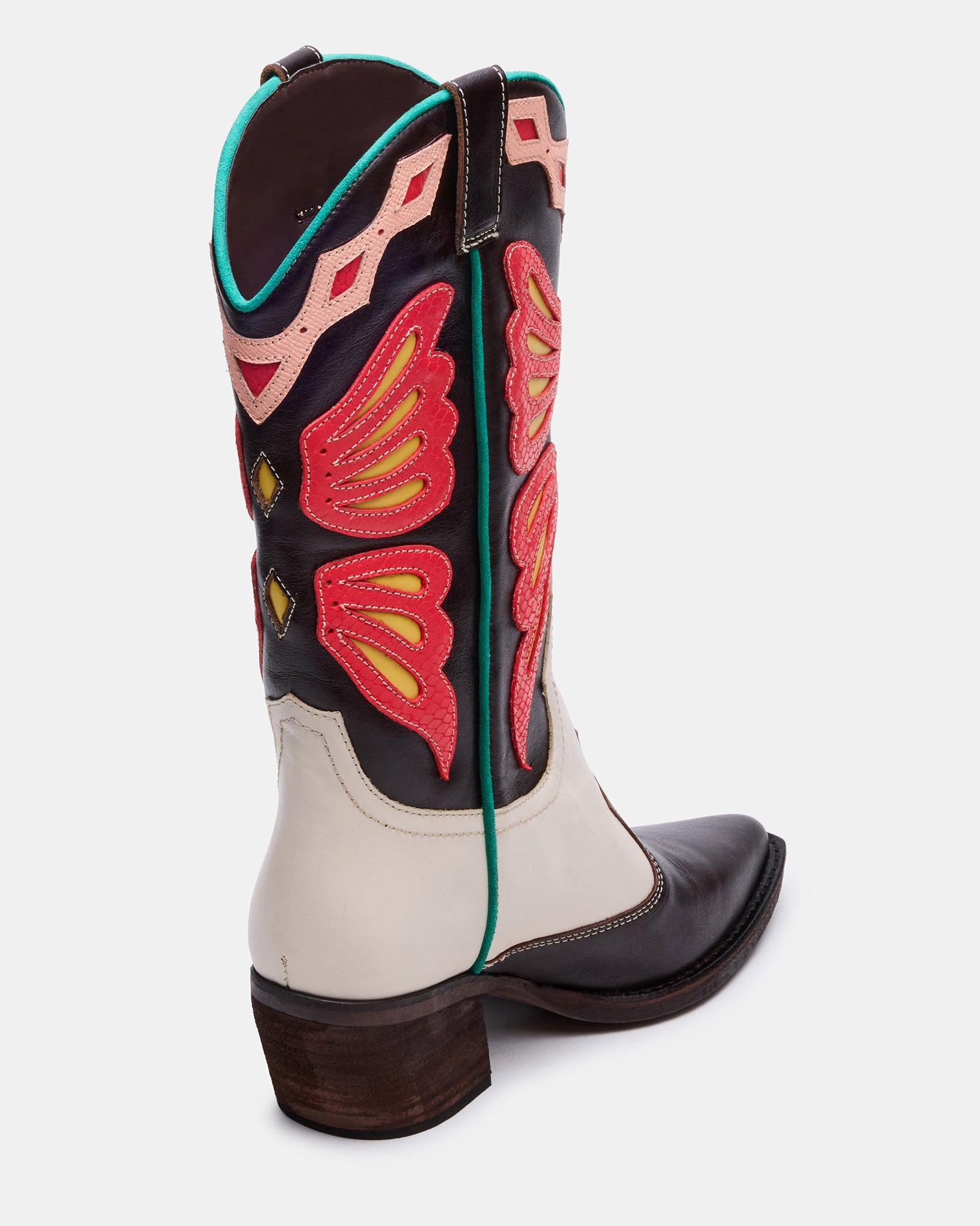 Woman wearing black western boots with a dress at a casual event.
