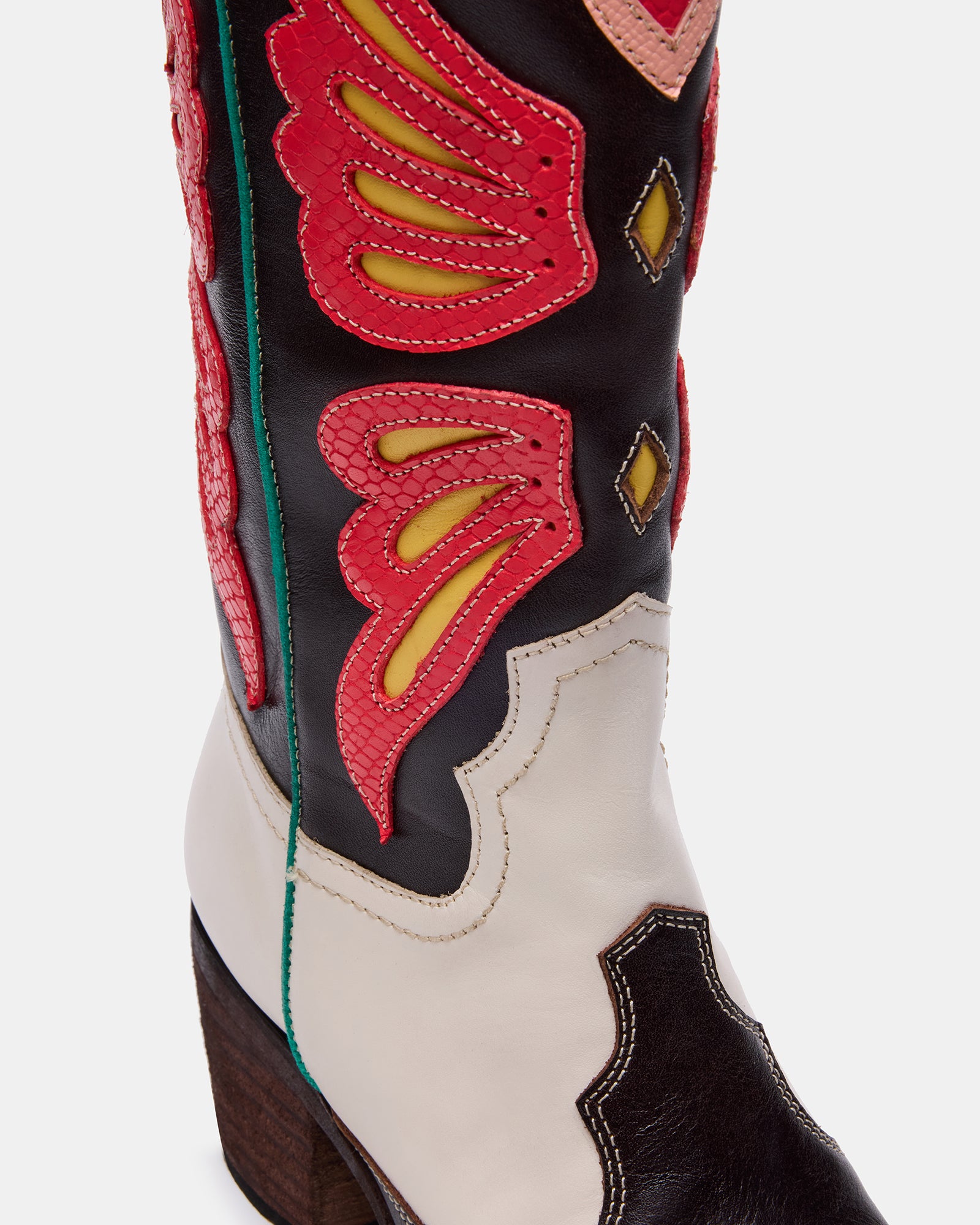 Side view of womens white cowboy boots paired with denim for a trendy look.
