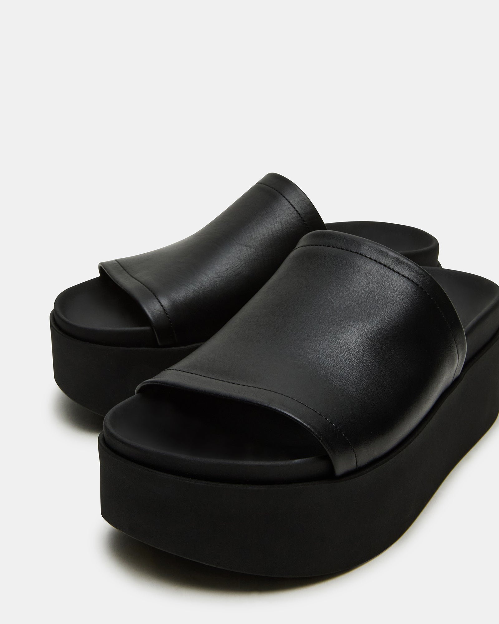 Styled shot of ARWEN black leather sandals paired with casual summer outfit