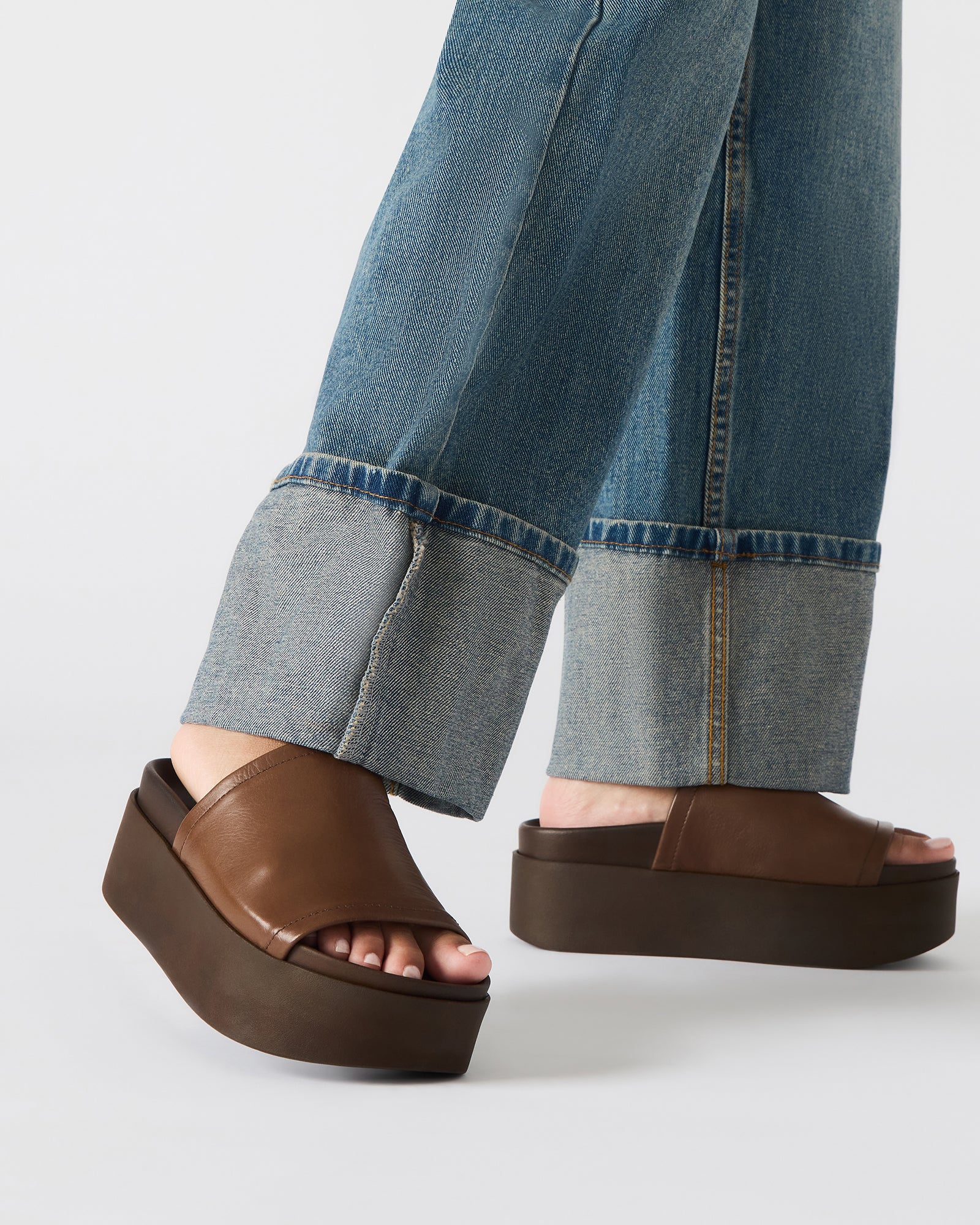 Styled shot of ARWEN black leather sandals paired with casual summer outfit