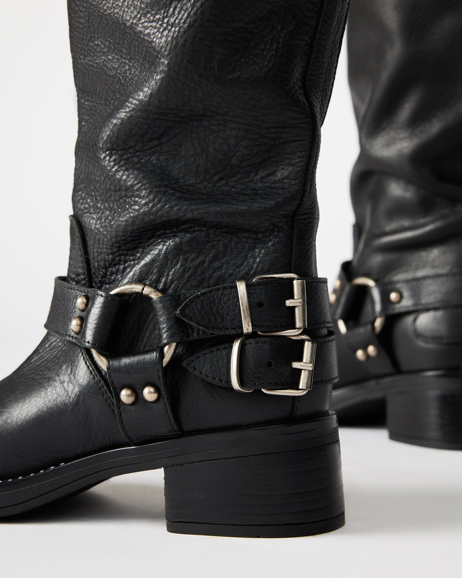 Close-up of strap hardware and heel of black leather engineer boots