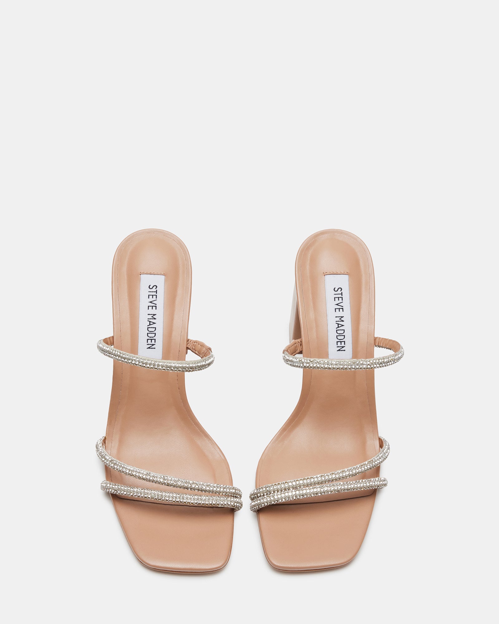 Stylish black block heel sandals worn by a woman at a summer party.