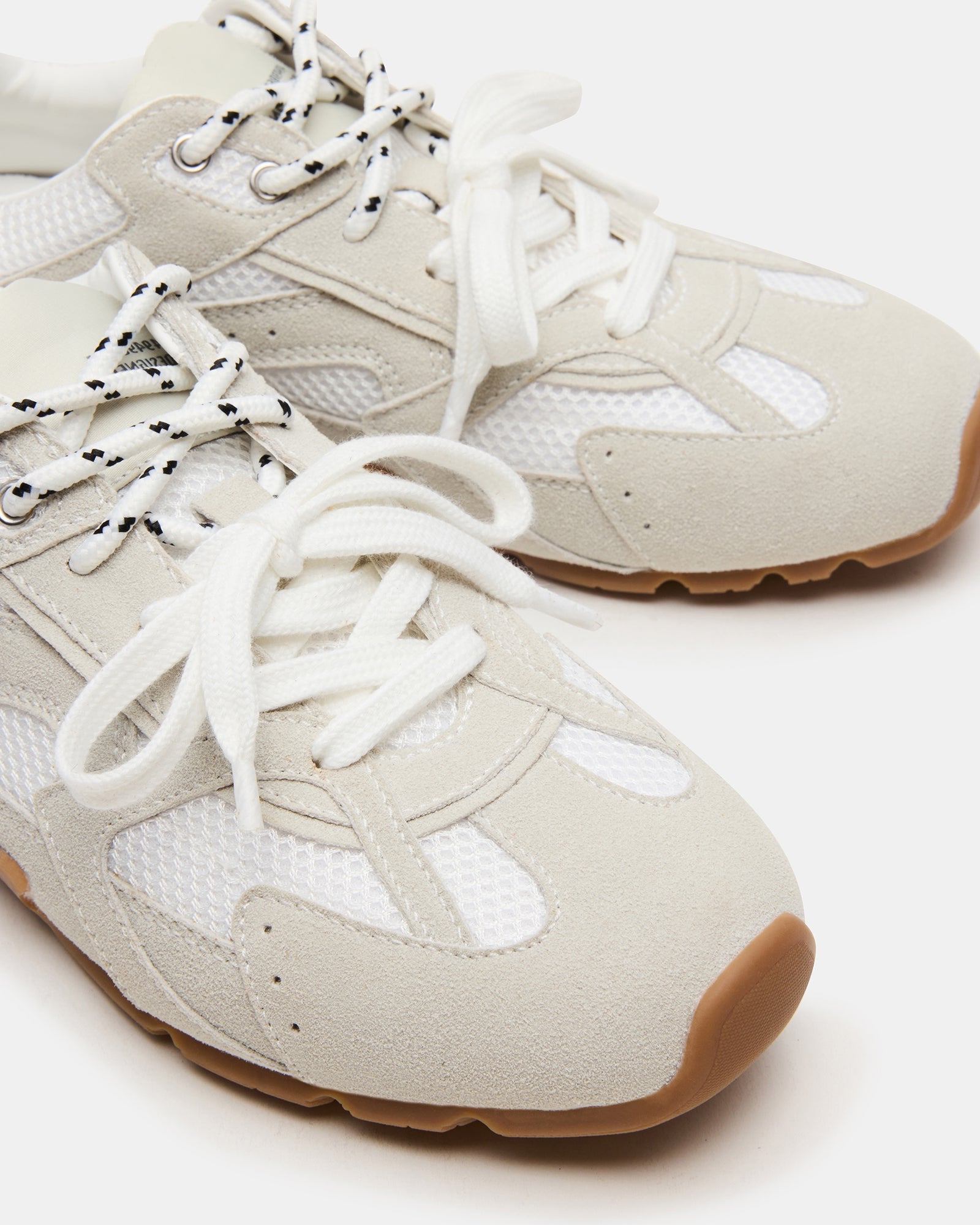 Aziel white suede sneakers styled with casual attire for everyday wear.