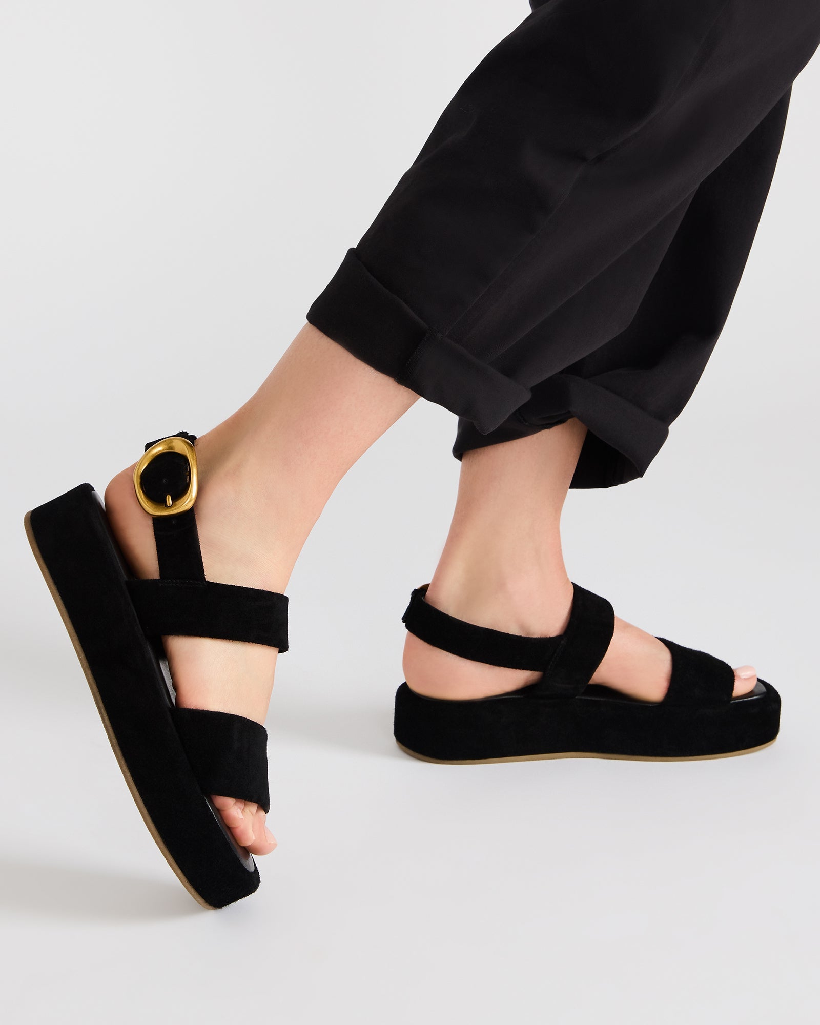Black suede sandals styled with summer outfit for a chic look.