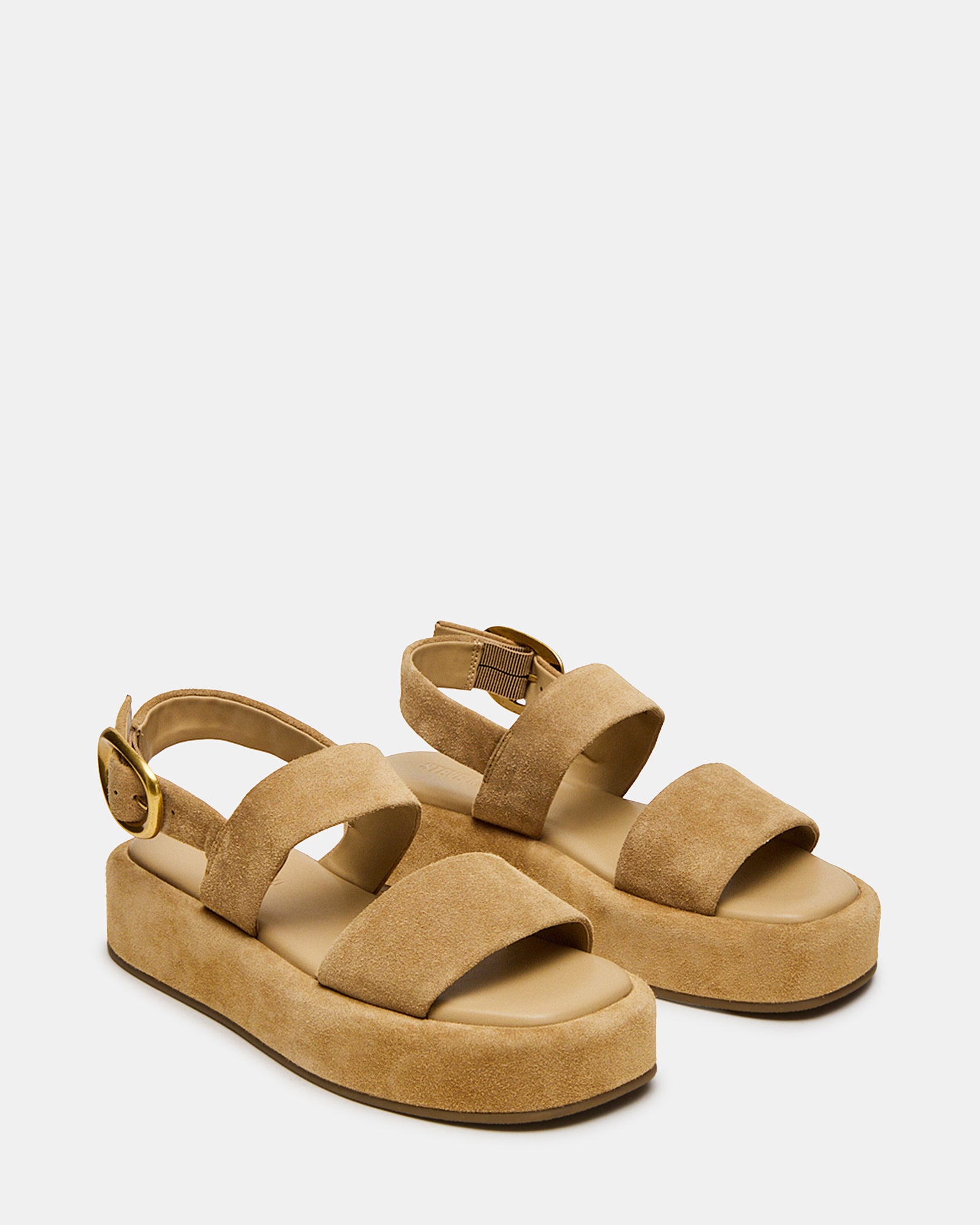 Stylish white platform sandals worn at a summer outdoor event.