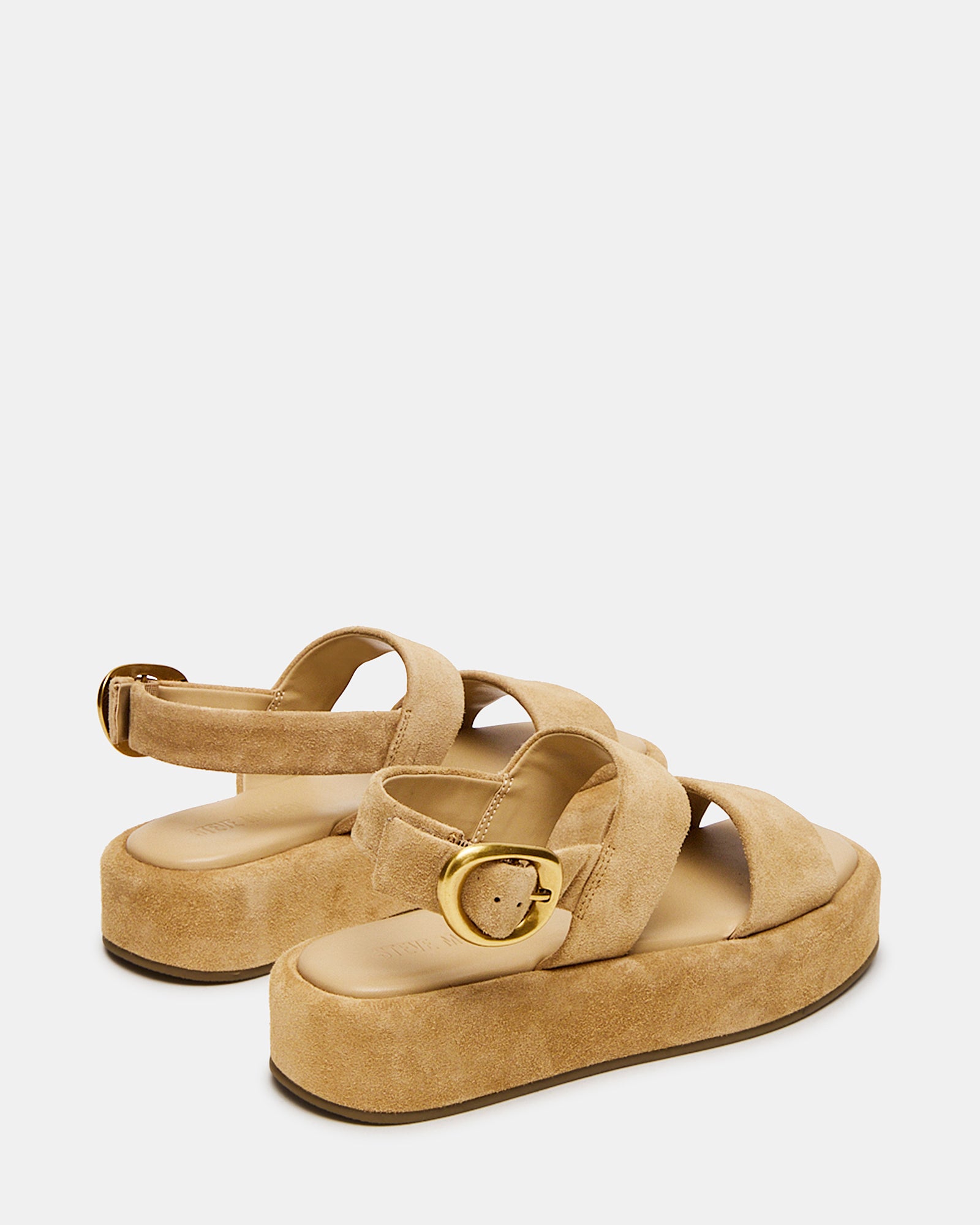Stylish white platform sandals worn at a summer outdoor event.