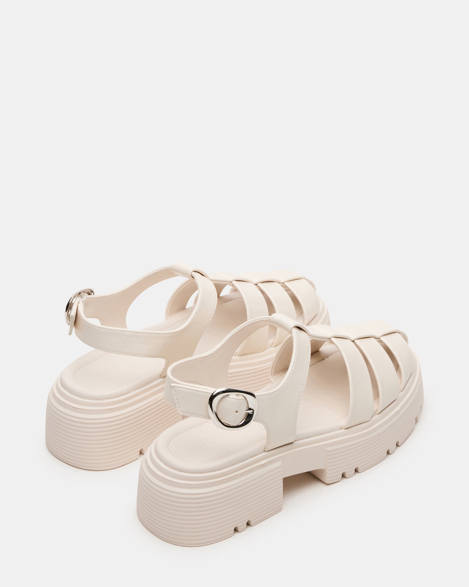 Model walking along the beach wearing BASS BONE vegan sandals with a 2-inch heel