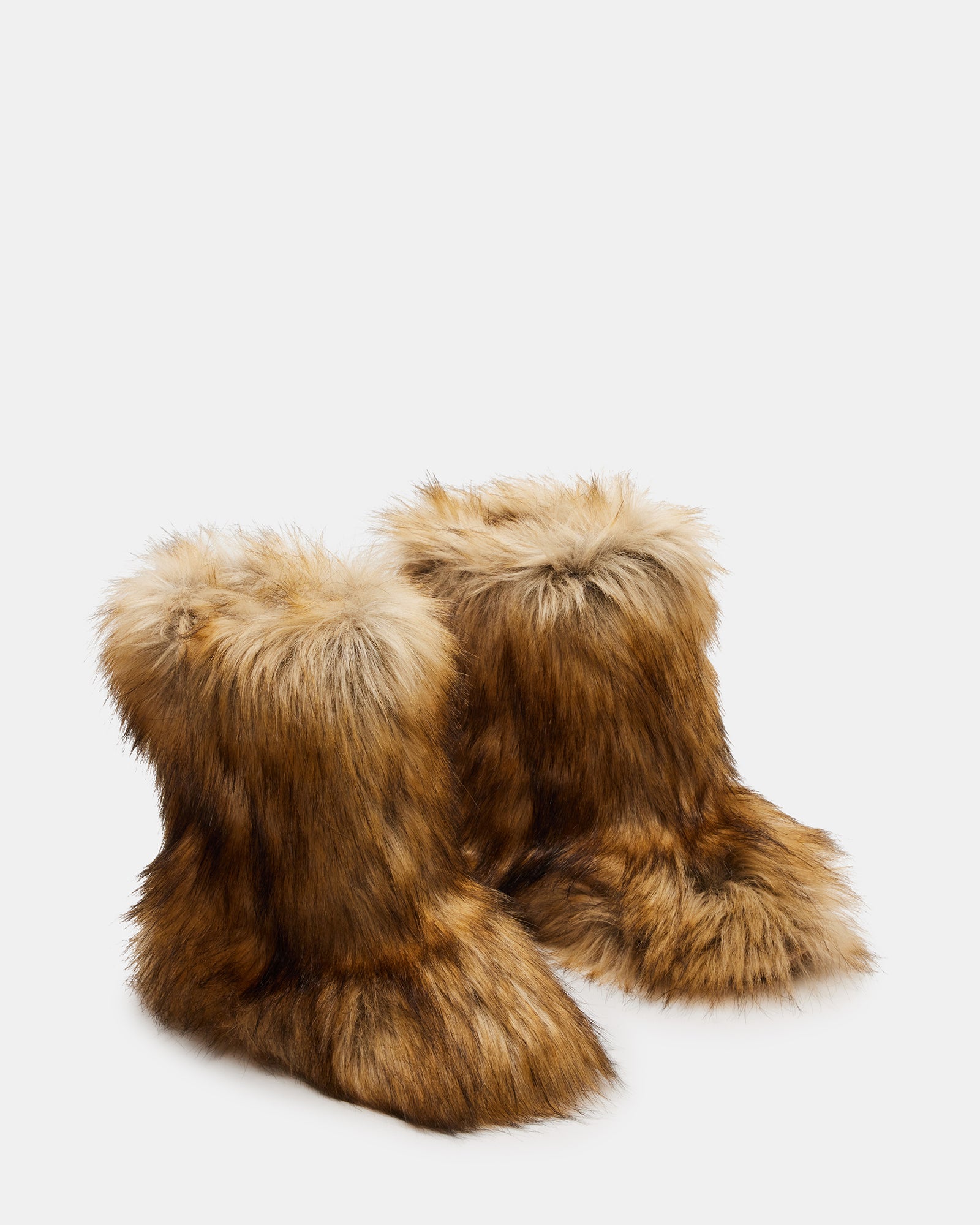 Model wearing stylish black ankle boots with faux fur at a winter event.