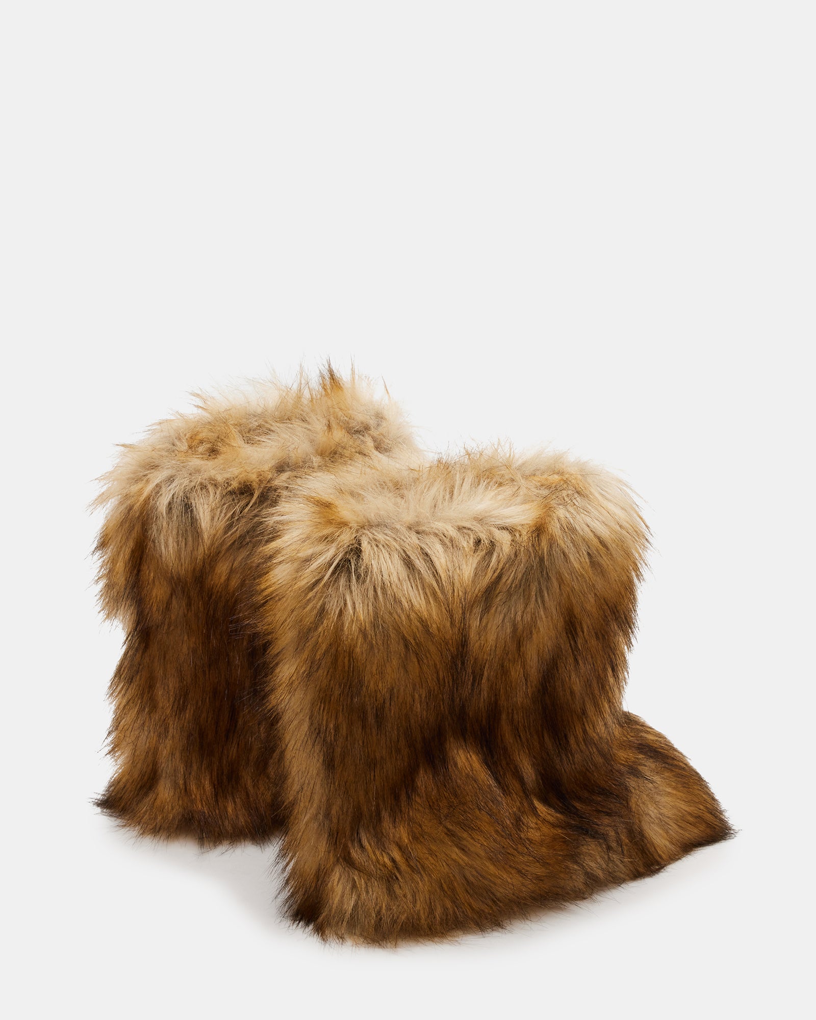 Model wearing stylish black ankle boots with faux fur at a winter event.
