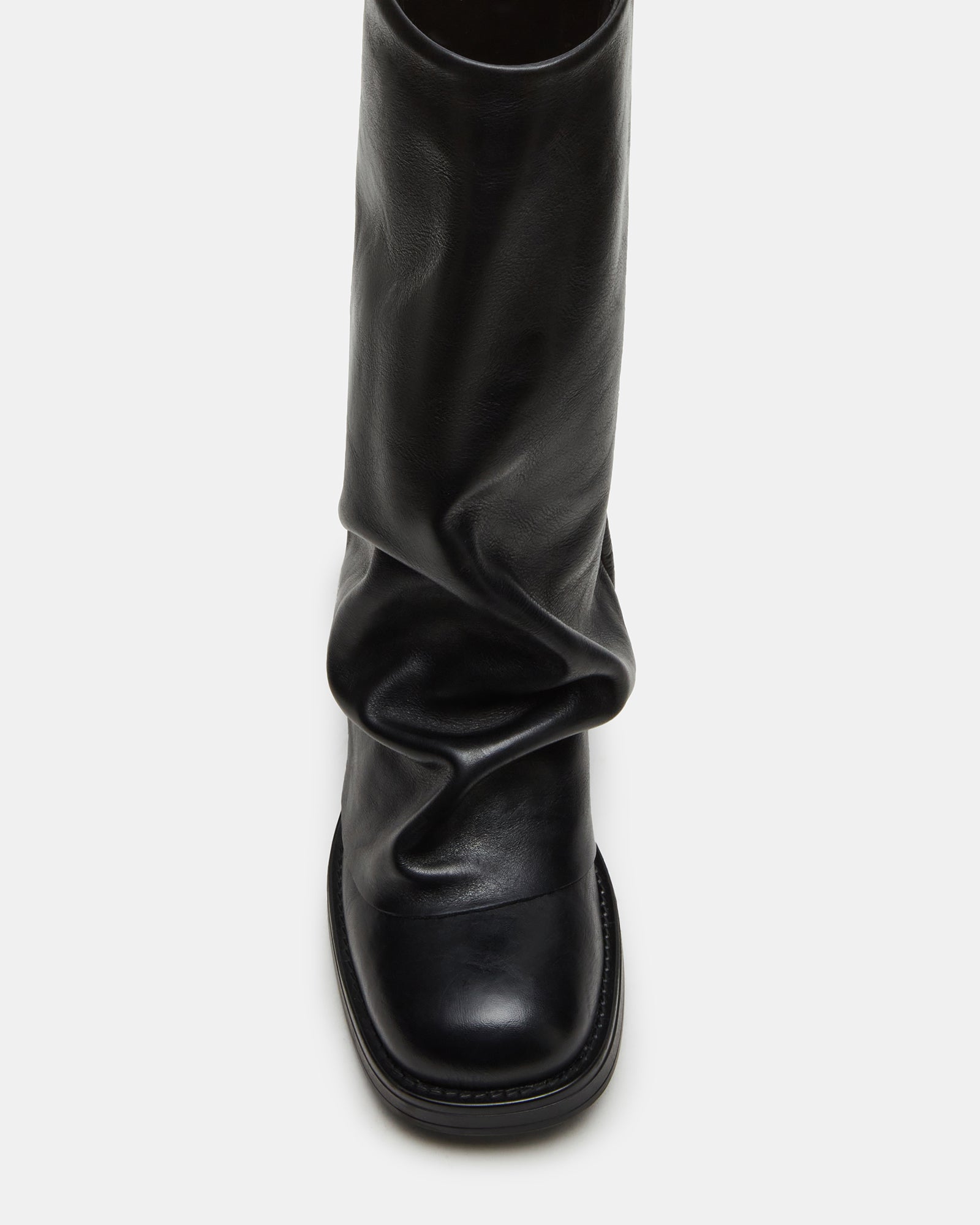 Front-facing black leather ankle boots styled with jeans for urban daywear