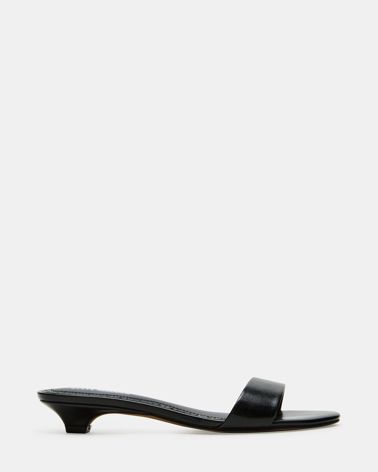 Side view of BERRY black vegan mule heels with kitten heel on a city street