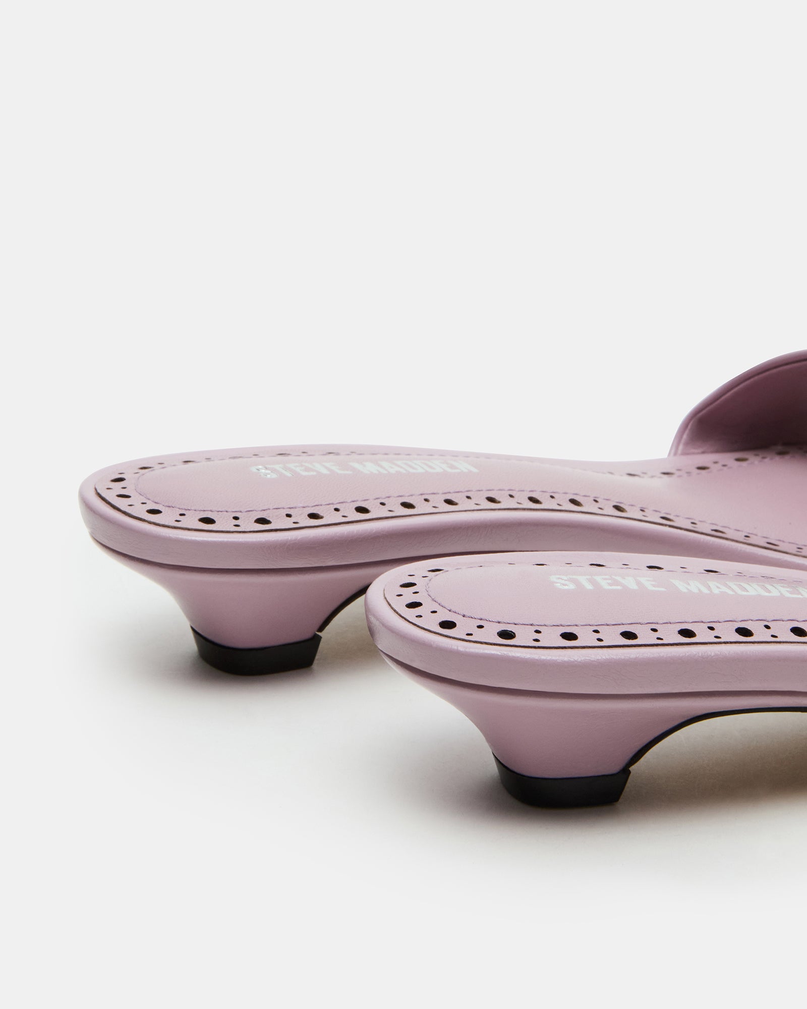 Berry mule shoes worn outdoors on sunny urban street