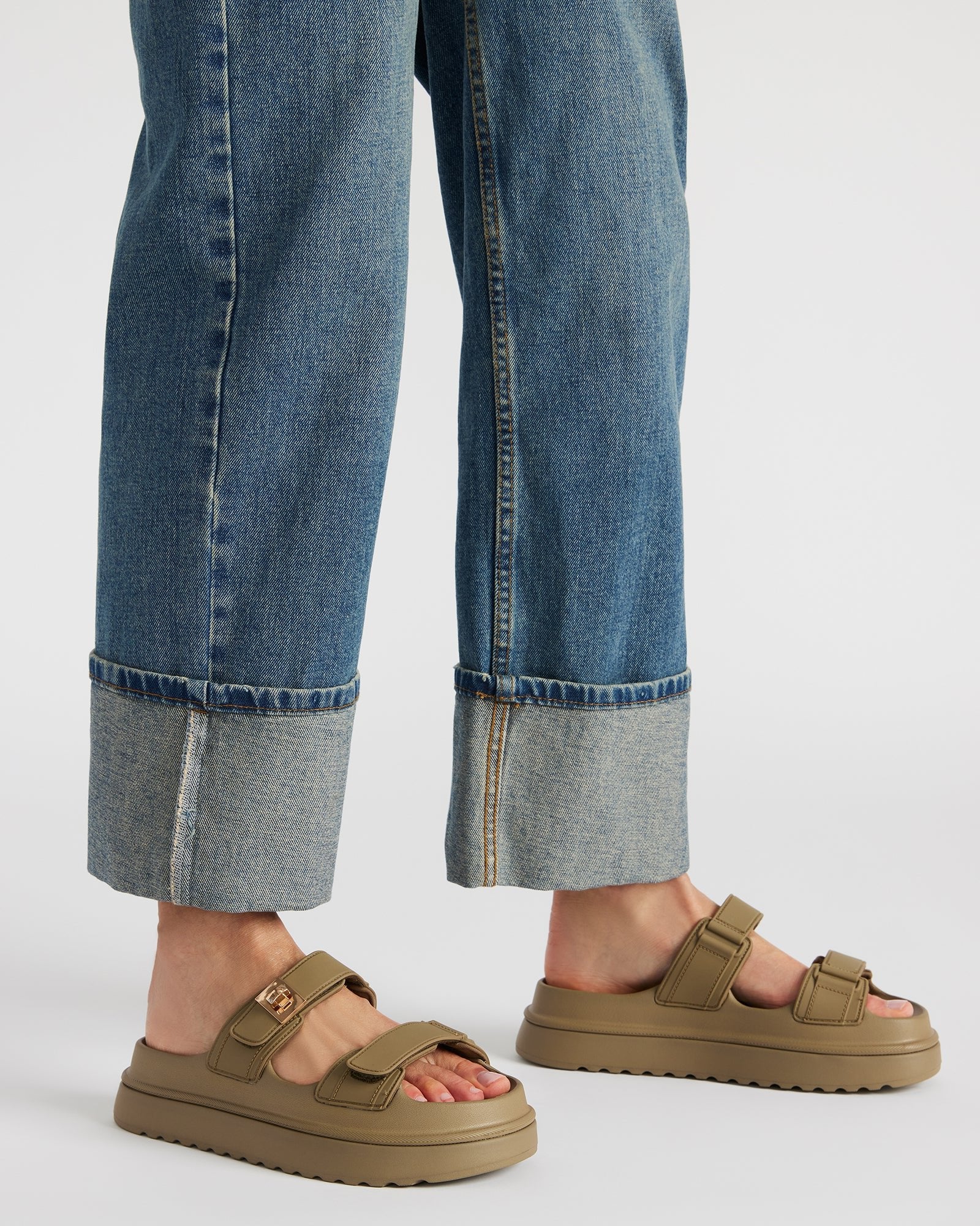 Top-down view of slide sandals with turn-lock accent on synthetic upper