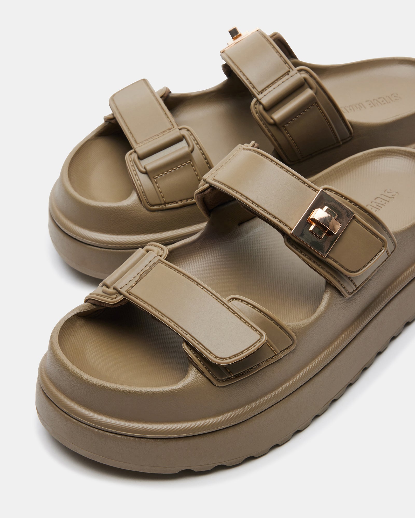 Close-up of olive jelly sandals showing platform heel and glossy finish