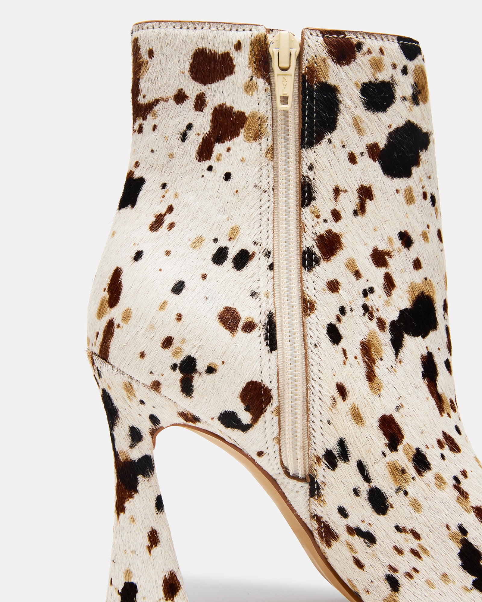 Black cow print booties styled with denim for a daytime look