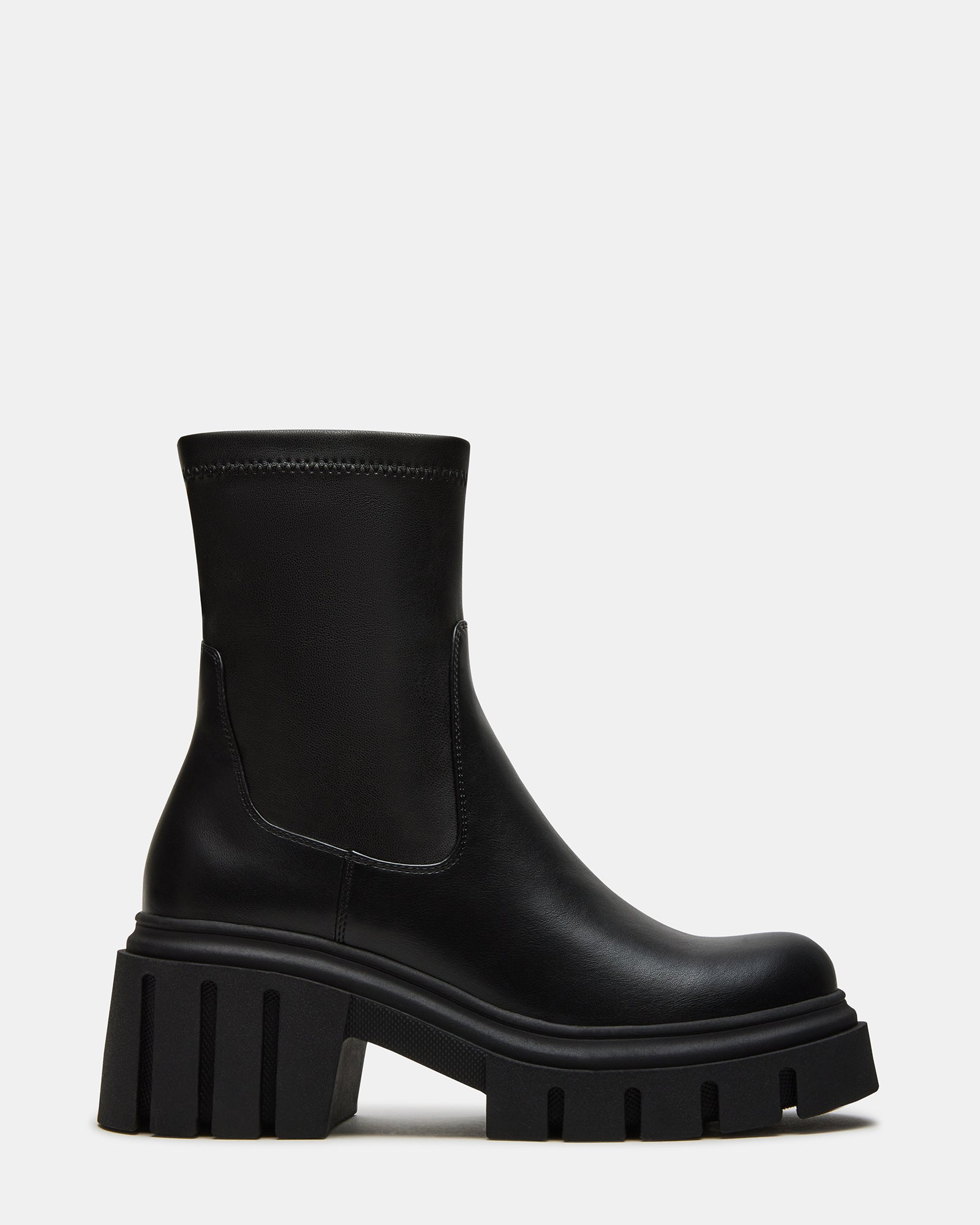 Front-facing view of black ankle boots styled with denim