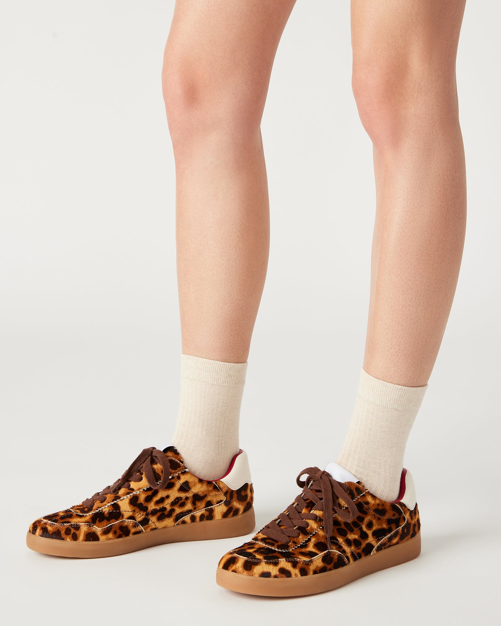 Braxton white sneakers worn casually in a sunny outdoor setting.