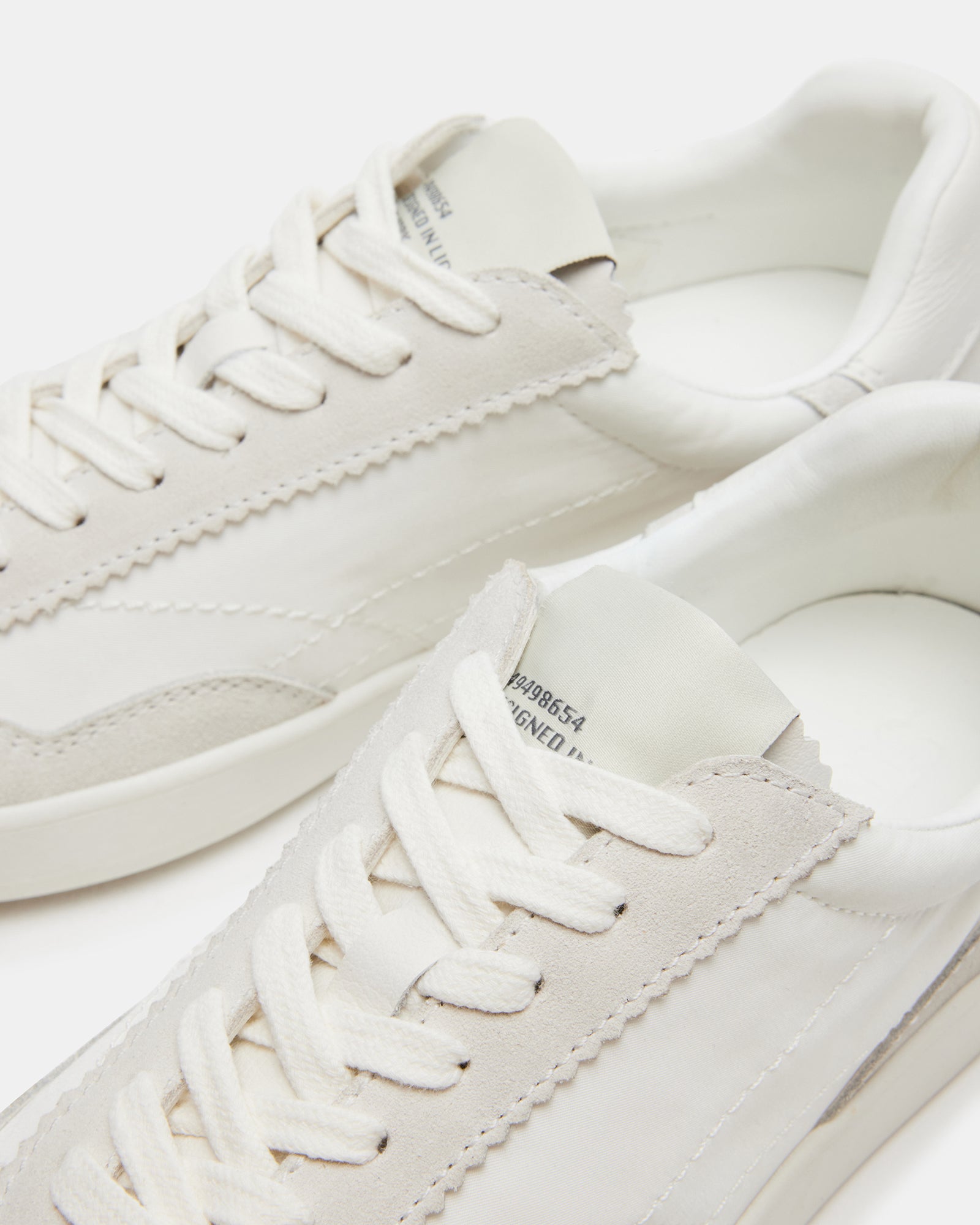 Braxton white sneakers worn casually in a sunny outdoor setting.