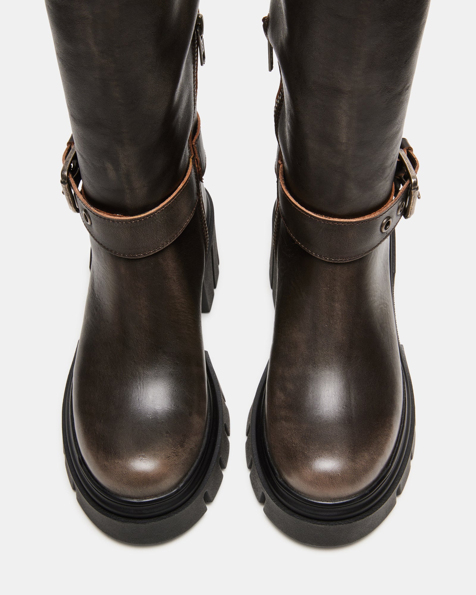 Side view of distressed brown knee-high boots with buckle accents