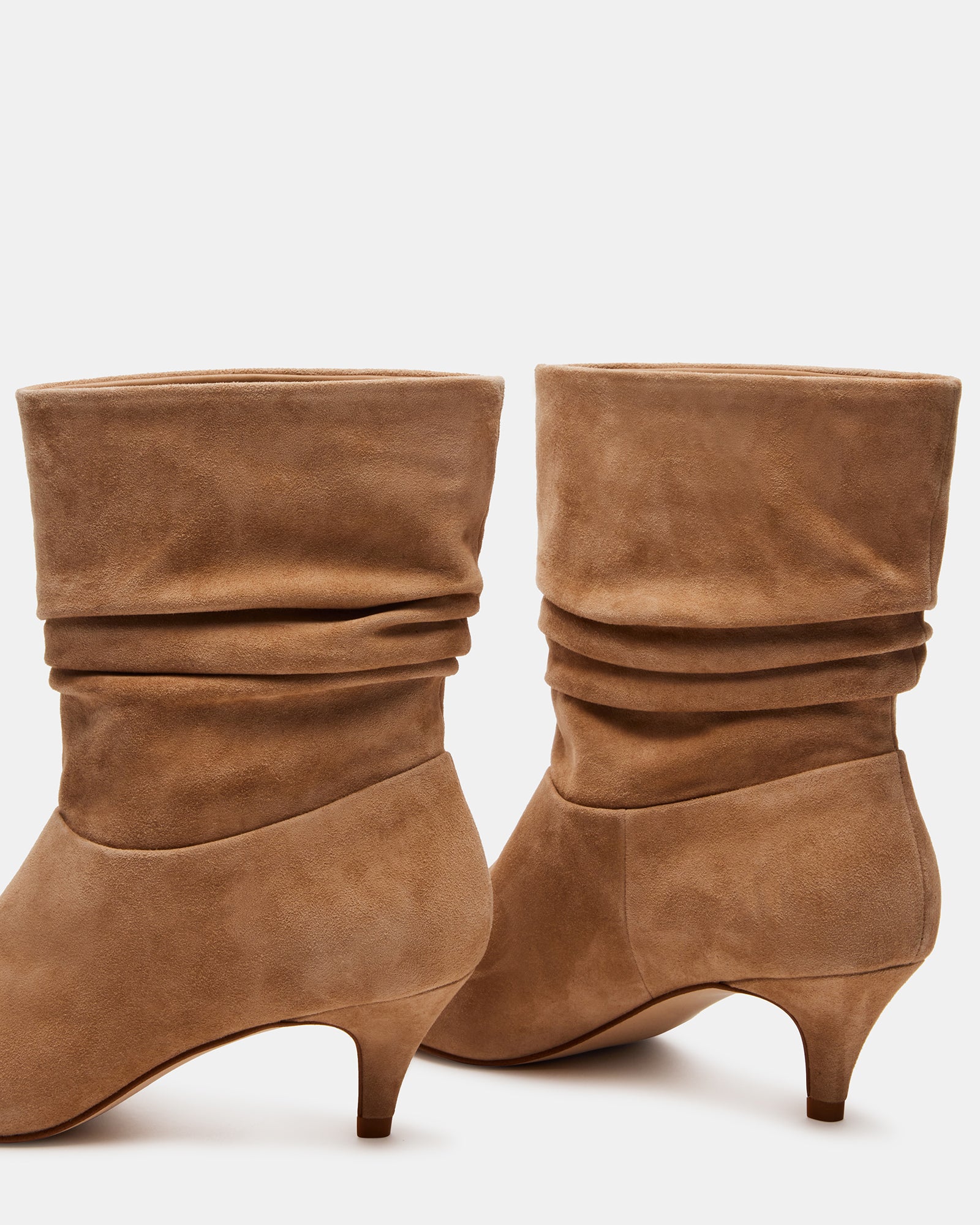 Brinwood suede booties worn with a stylish outfit on a city street.