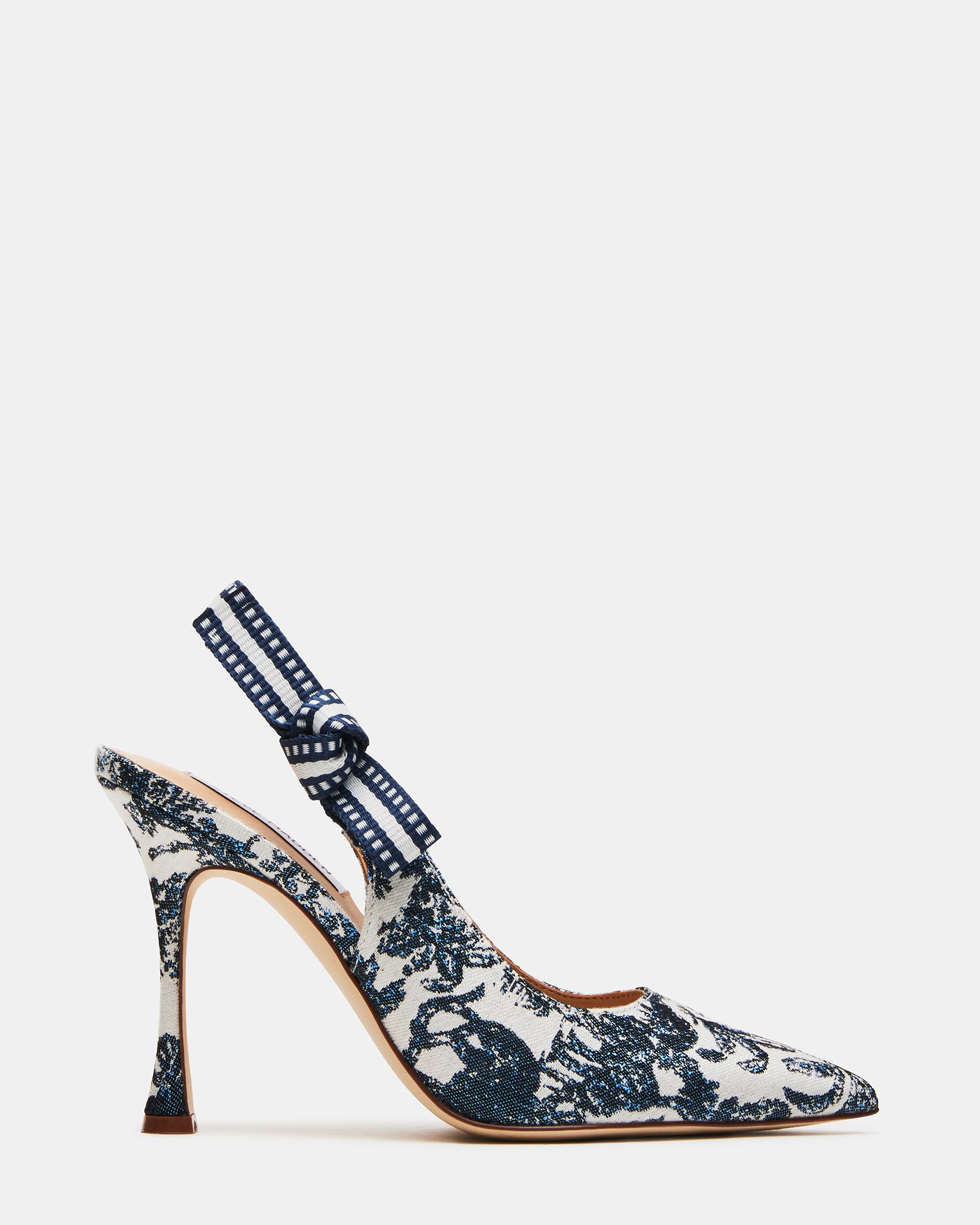 White slingback heels on a marble floor, showcasing pointed toe design
