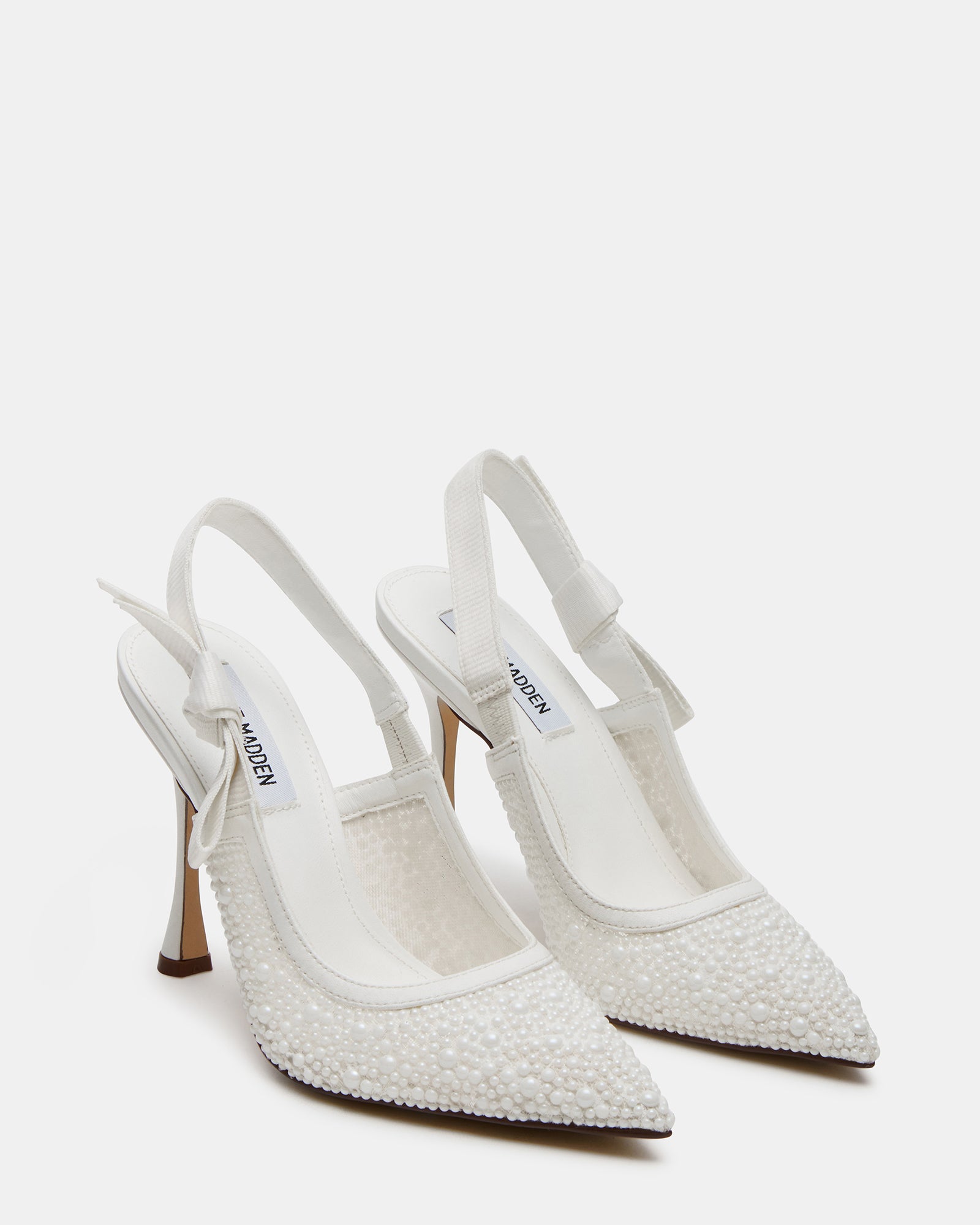 Close-up of the bow detail on the slingback strap of the white lace pumps.