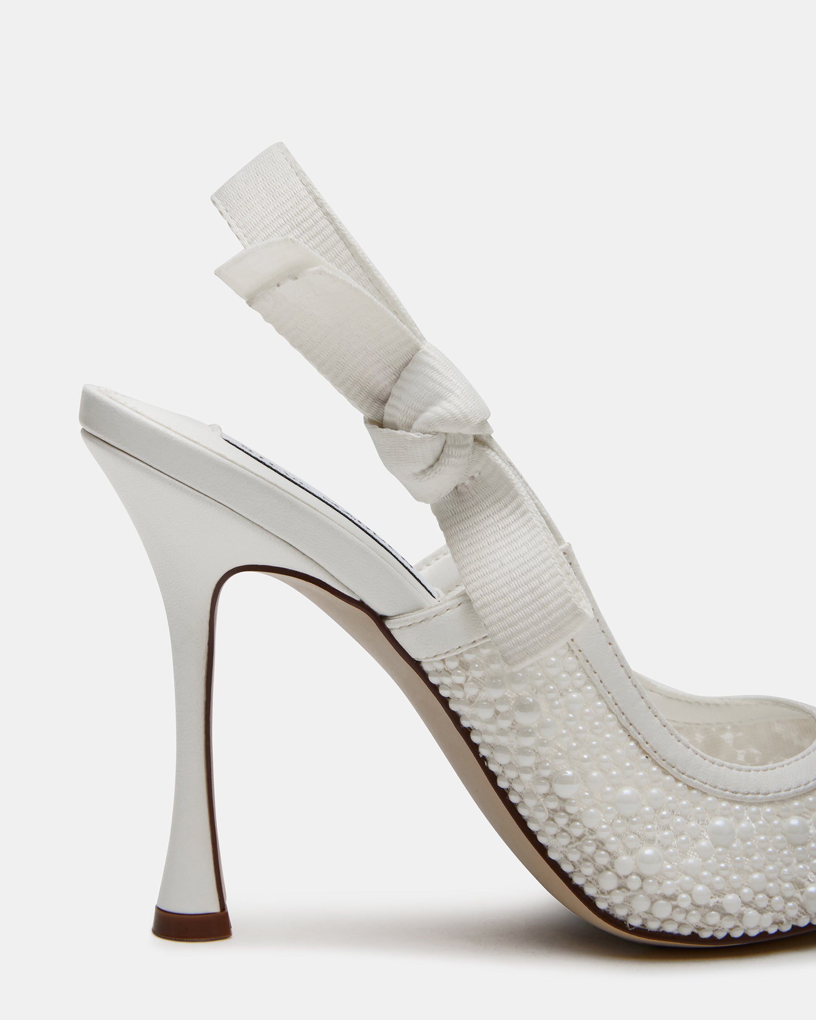Elegant white lace high heels displayed on a stylish surface.