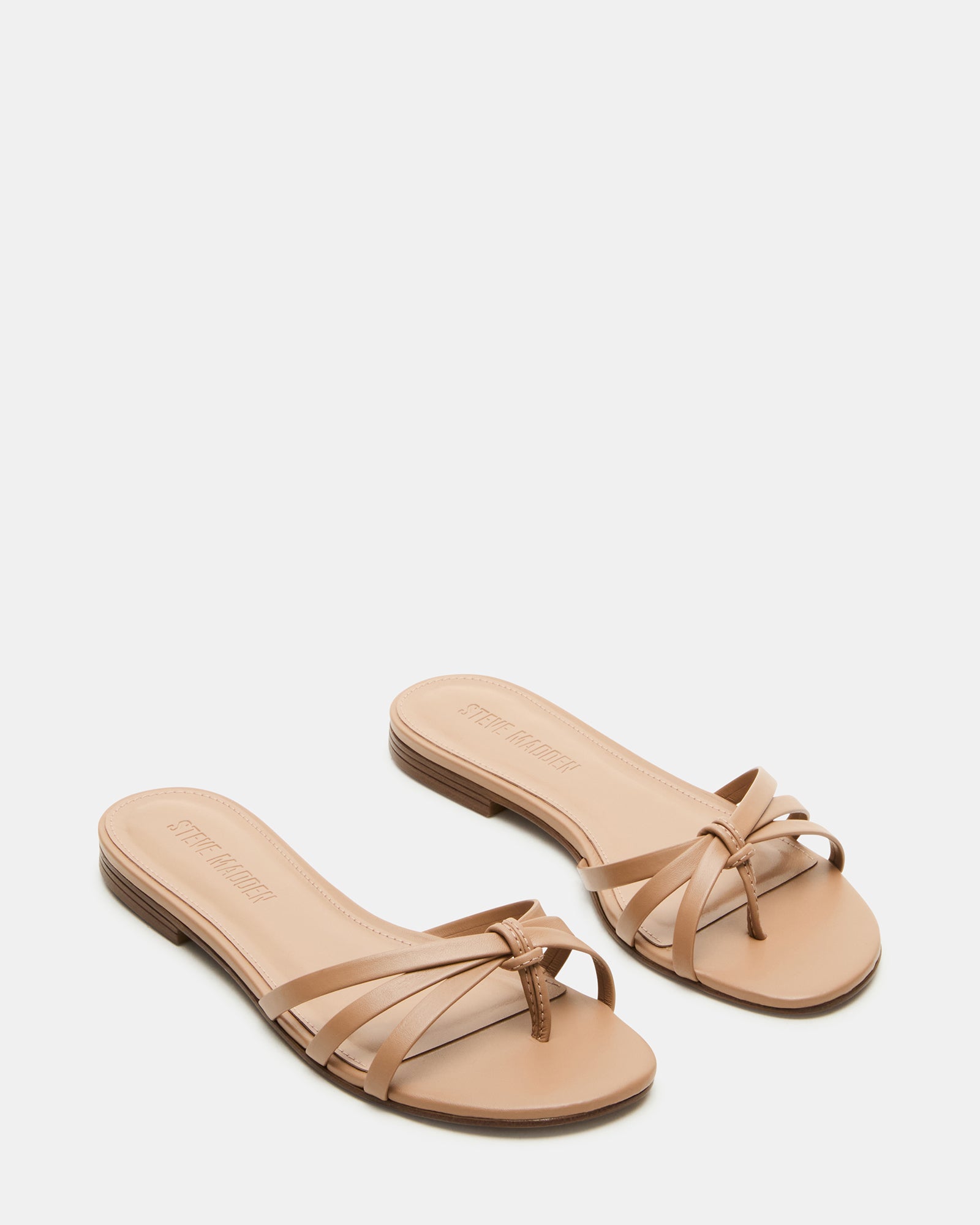 Calissi flat slide sandals on beach towel during weekend getaway.