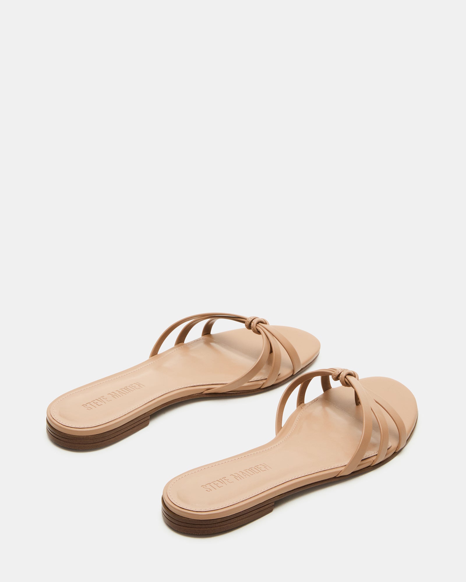 Calissi flat slide sandals on beach towel during weekend getaway.