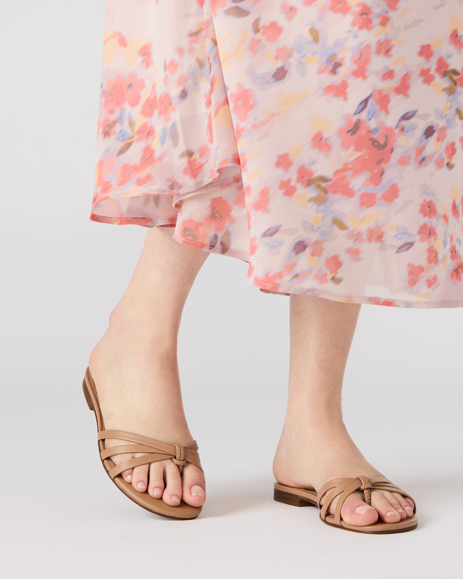 Top-down shot of black leather sandals styled with relaxed linen pants.
