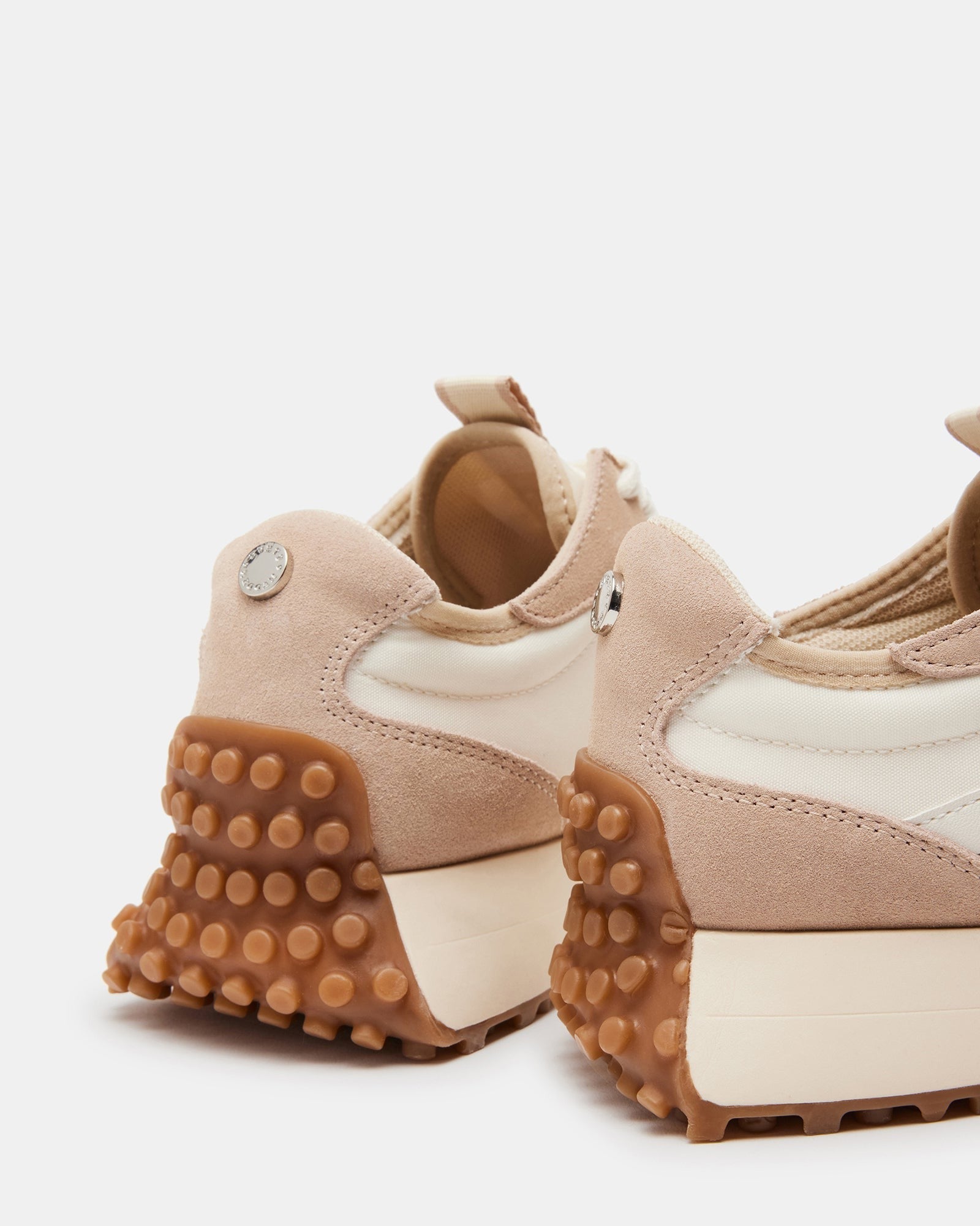 Front view of beige platform sneakers on a wooden surface