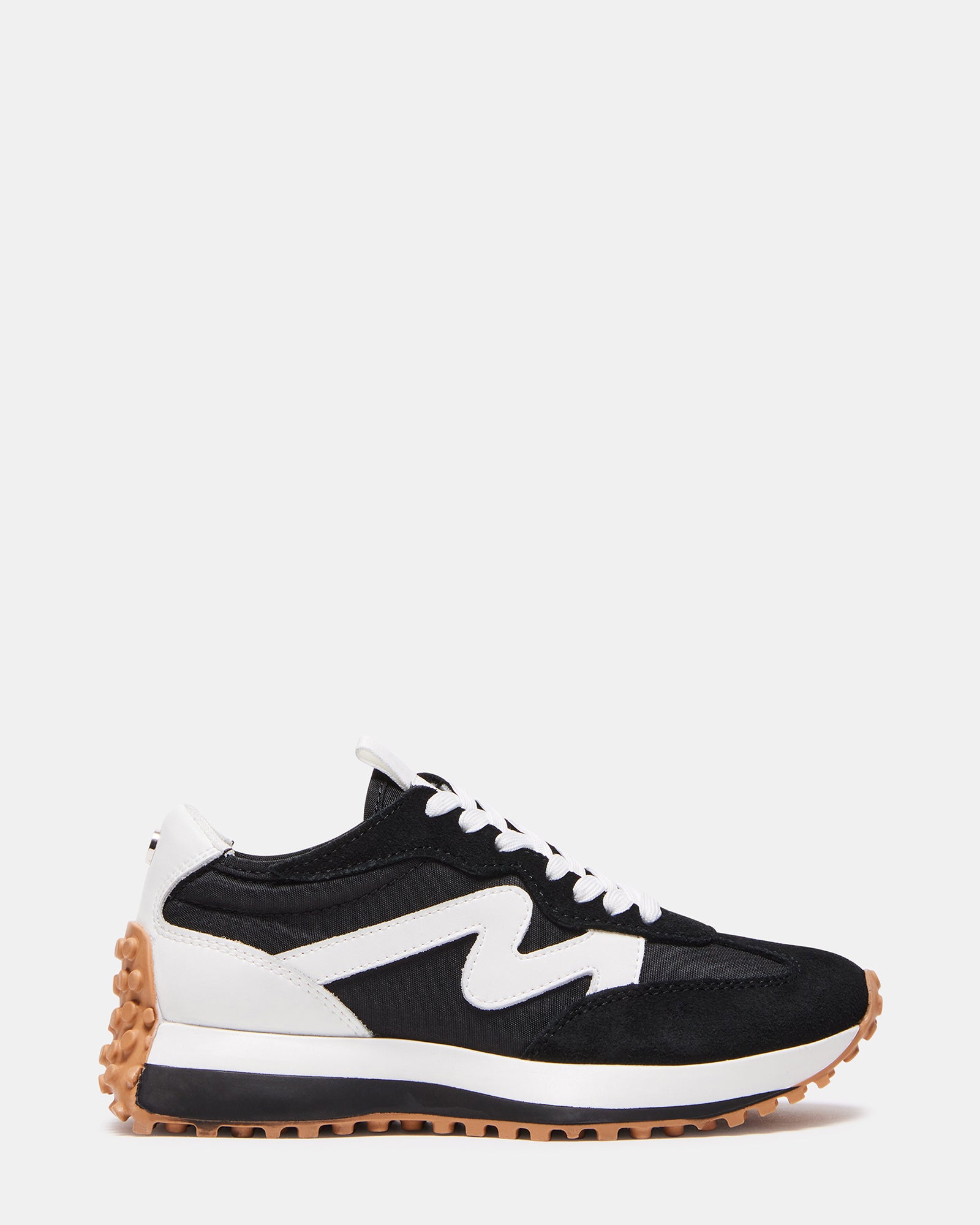 Side view of CAMPO black and white platform sneakers on pavement