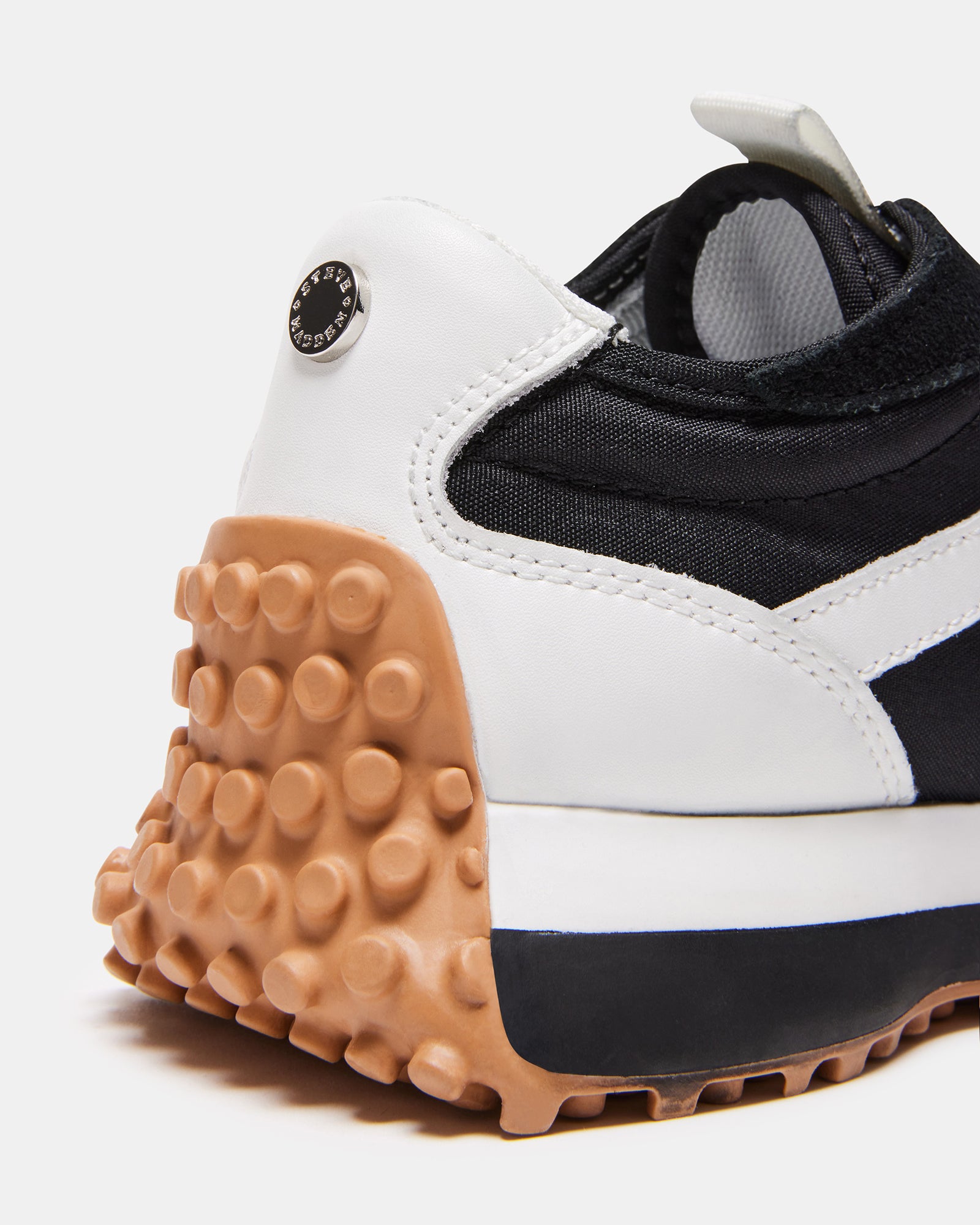 Side view of CAMPO black and white platform sneakers on pavement