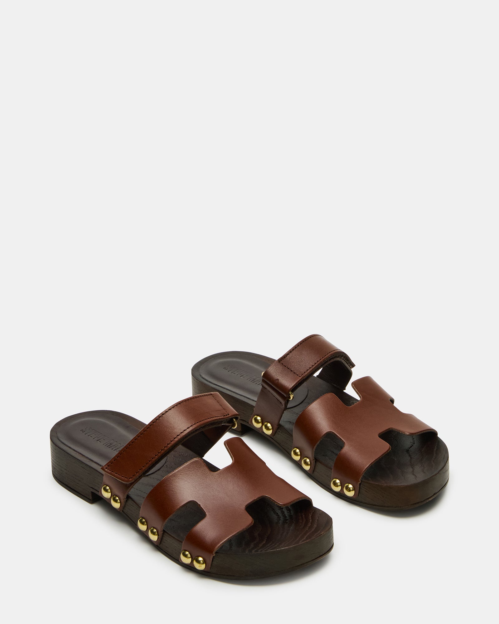 Side view of brown slide sandals with wood bottom