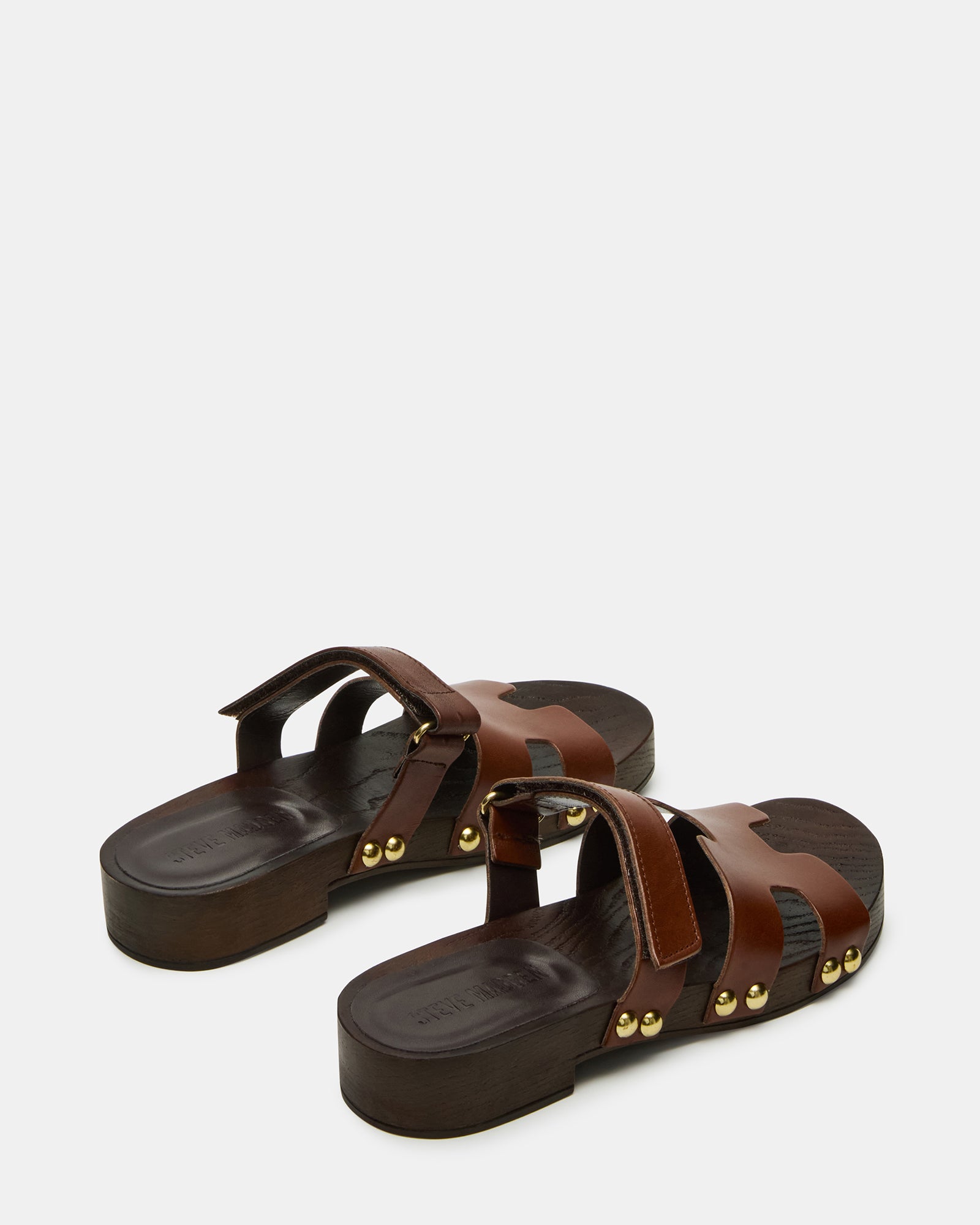 Side view of brown slide sandals with wood bottom